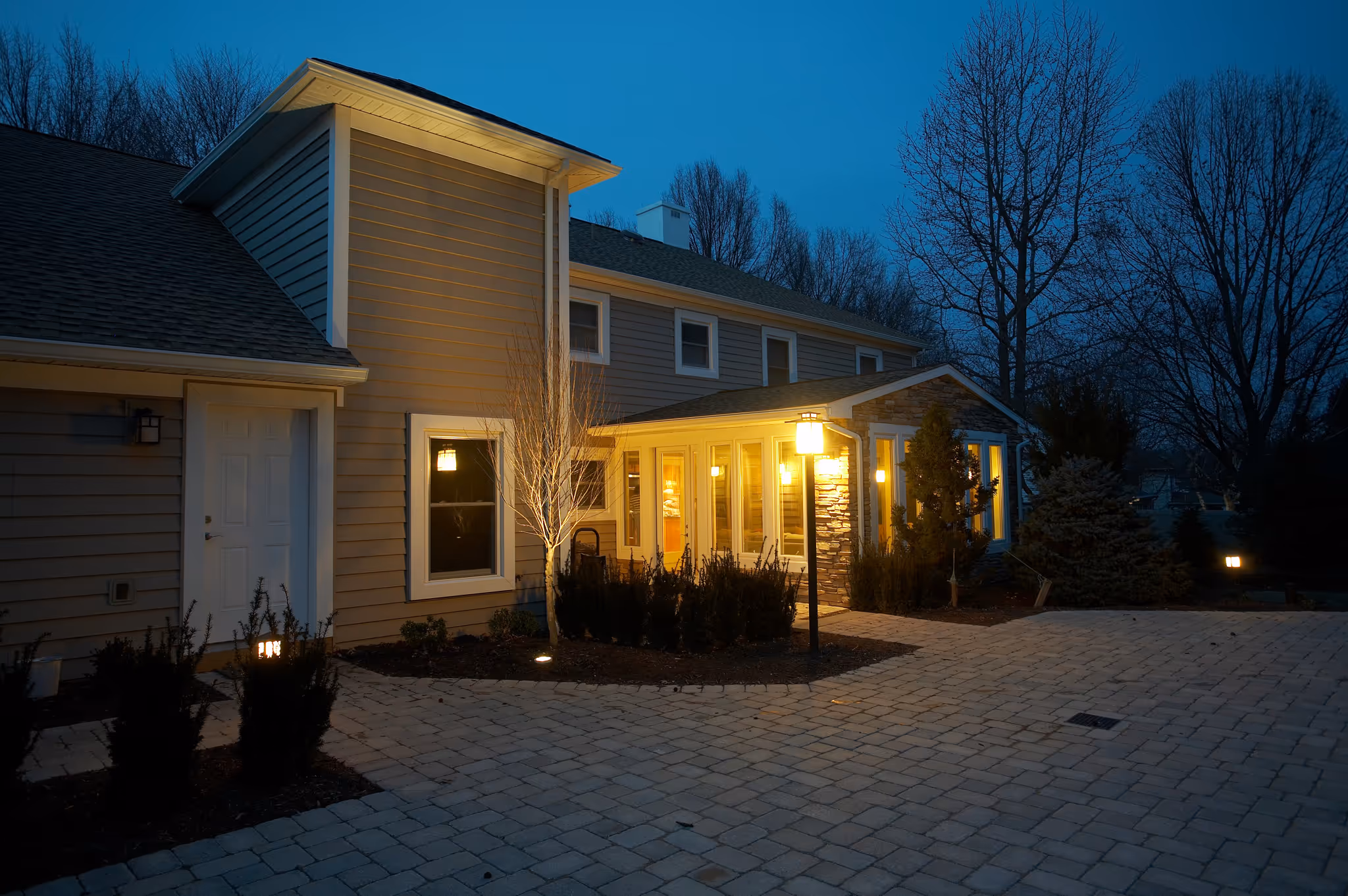 Contemporary exterior of a home in camp hill, pa featuring pathway lights, stone accents, and a welcoming entrance.