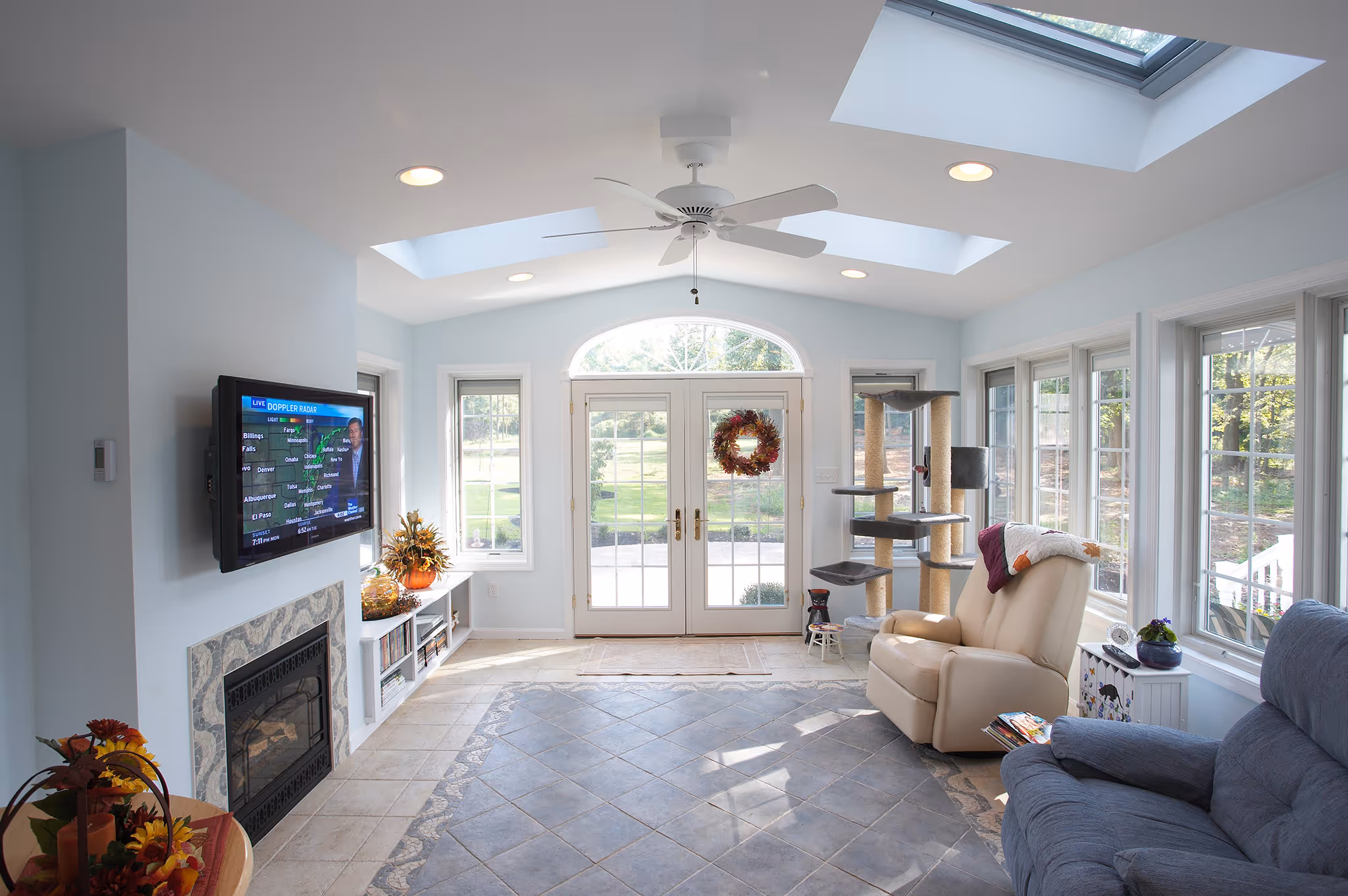 Bright sunroom in middletown, pa featuring large windows, light blue walls, and a cozy seating area.
