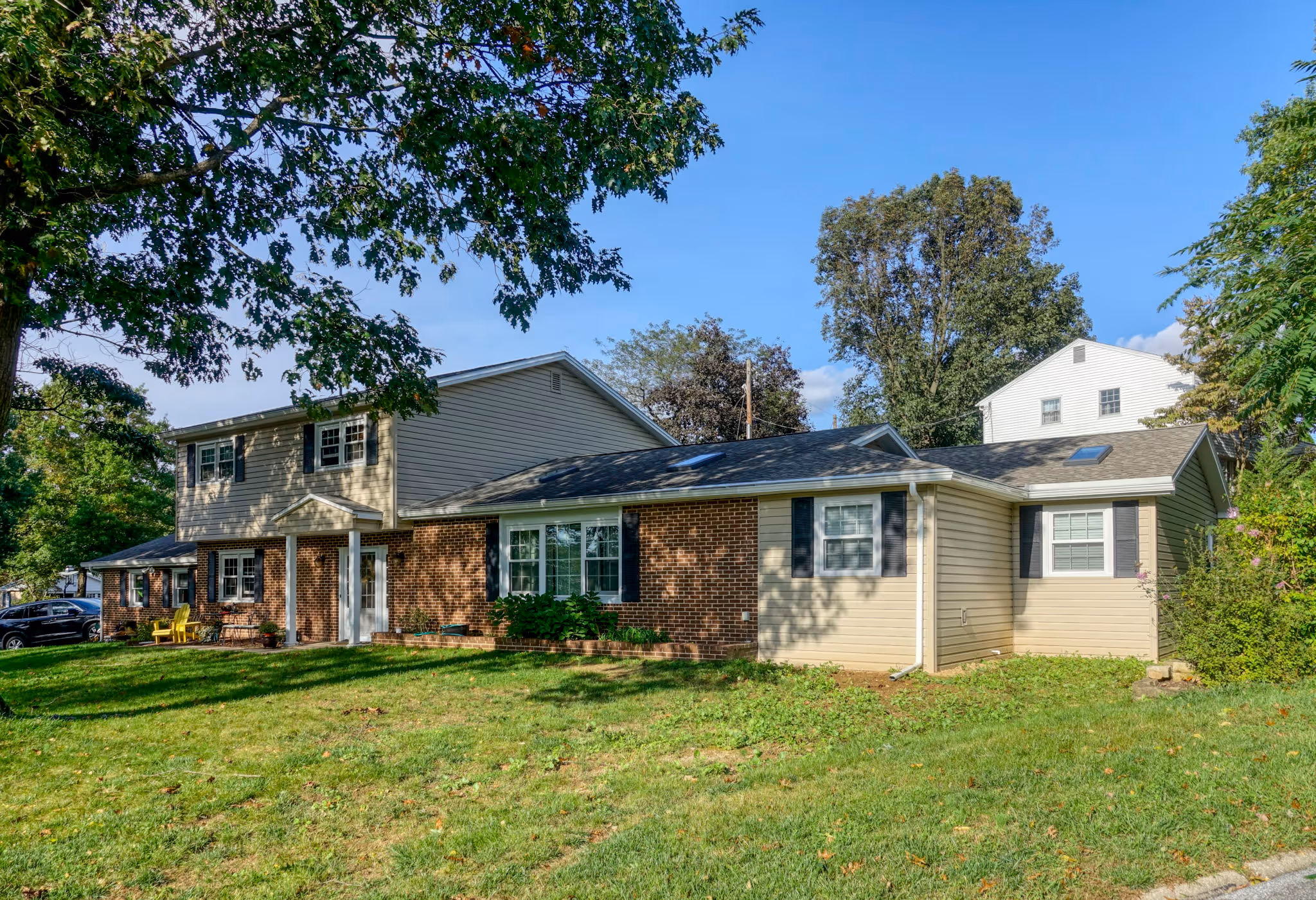 Contemporary exterior of a house in Mechanicsburg, PA with a mix of brick and siding, well-maintained lawn, and large windows.