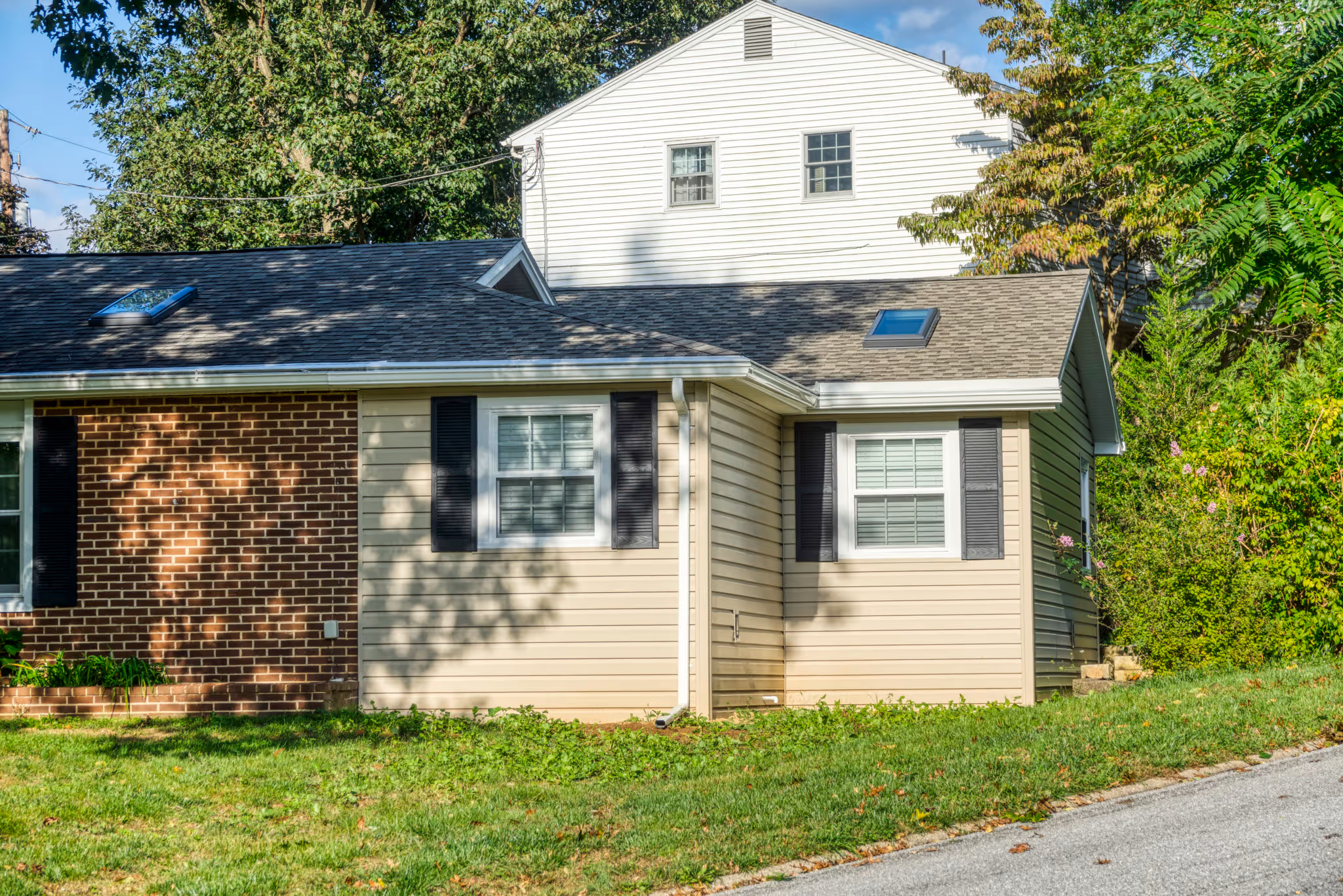 Modern exterior view of a home with brick and siding in Mechanicsburg, PA, featuring large windows and landscaping.
