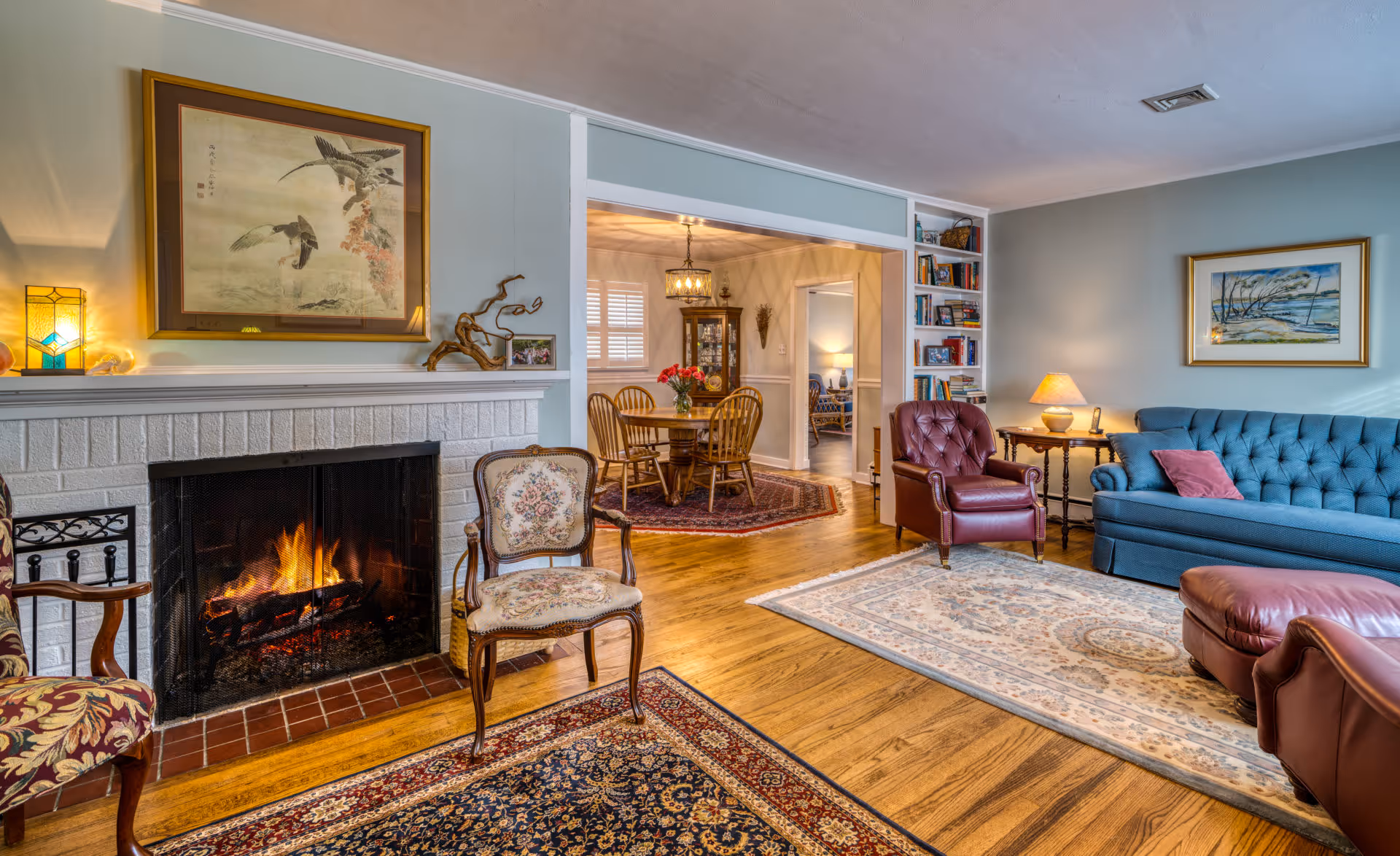Cozy living room with a fireplace, blue tufted sofa, and vintage decor in Camp Hill, PA.
