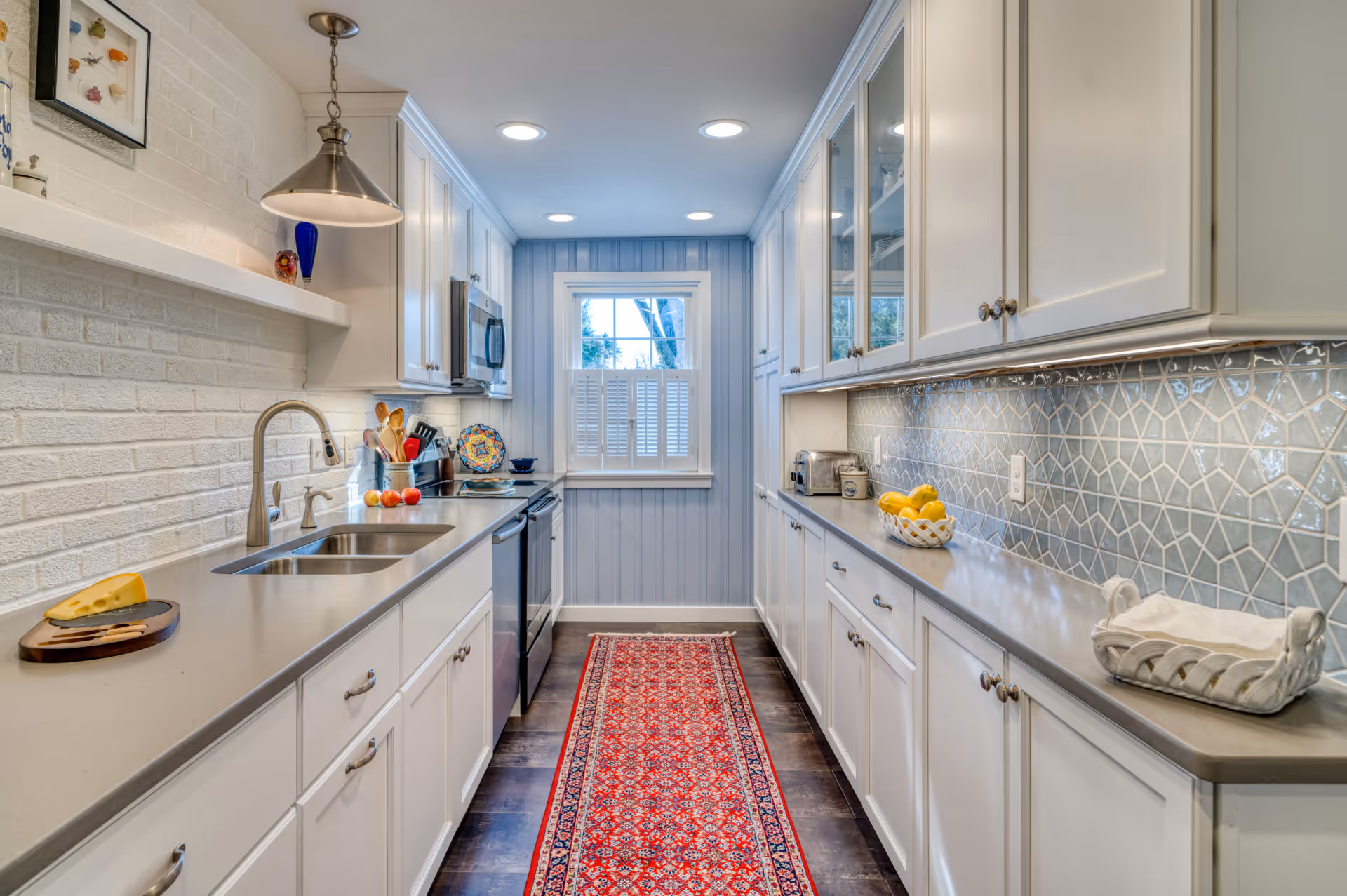Contemporary kitchen featuring light gray countertops, white cabinetry, and decorative blue tile backsplash in Camp Hill, PA.