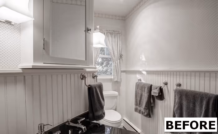 Cozy transitional bathroom in camp hill, pa with black countertop, white shiplap walls, and ample natural light.