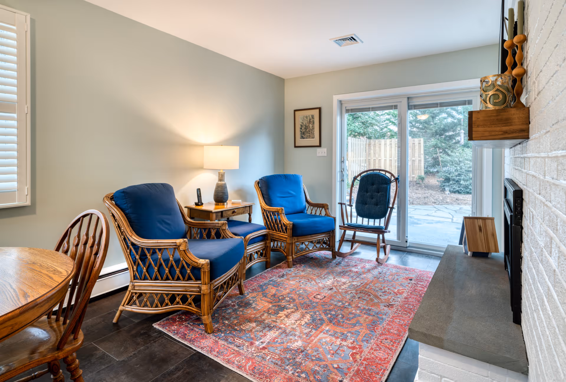 Cozy living room in Camp Hill, PA featuring blue upholstered chairs, a vintage rug, and sliding doors to the outside.