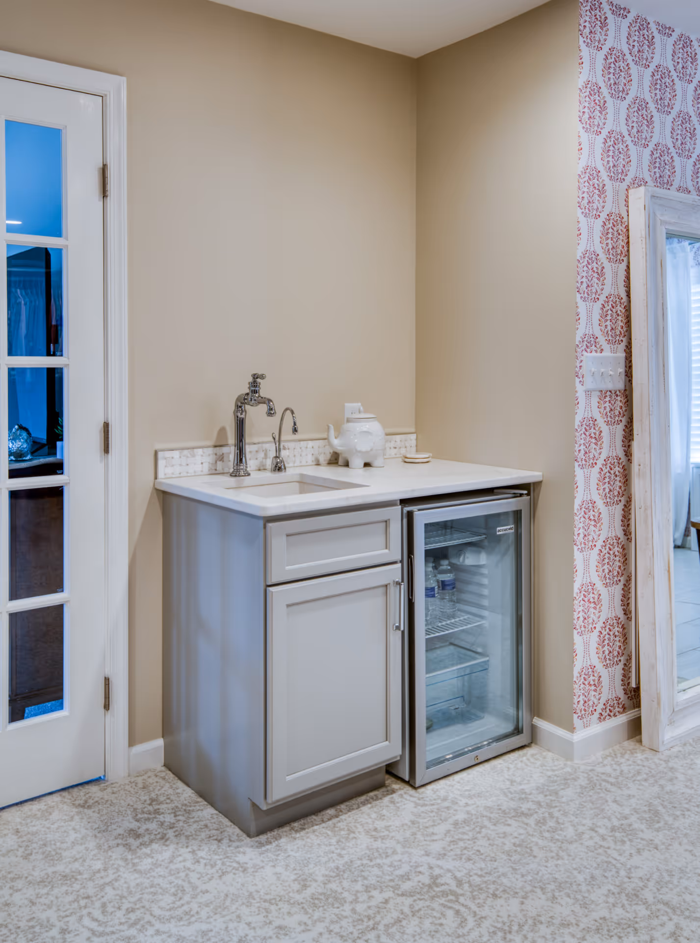 Cozy wet bar area featuring gray cabinetry, a silver faucet, and a stylish wallpaper design in Elizabethtown, PA.