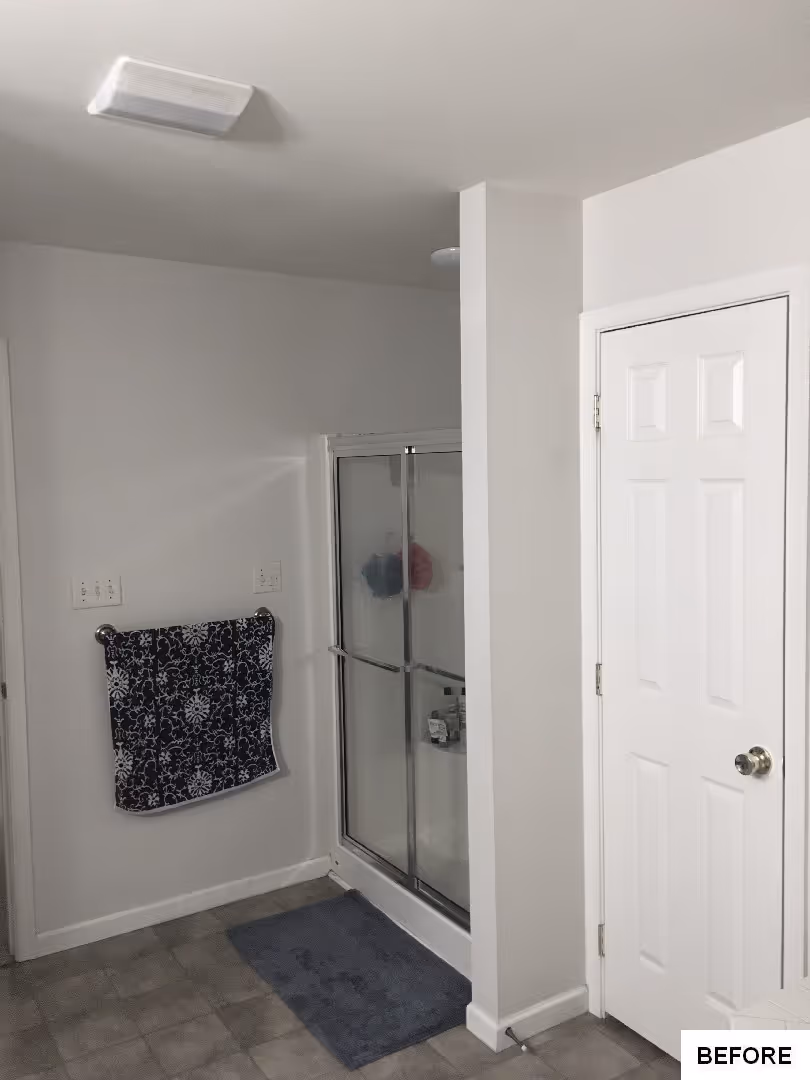 Modern bathroom with glass shower, navy accents, and neutral walls in Elizabethtown, PA.