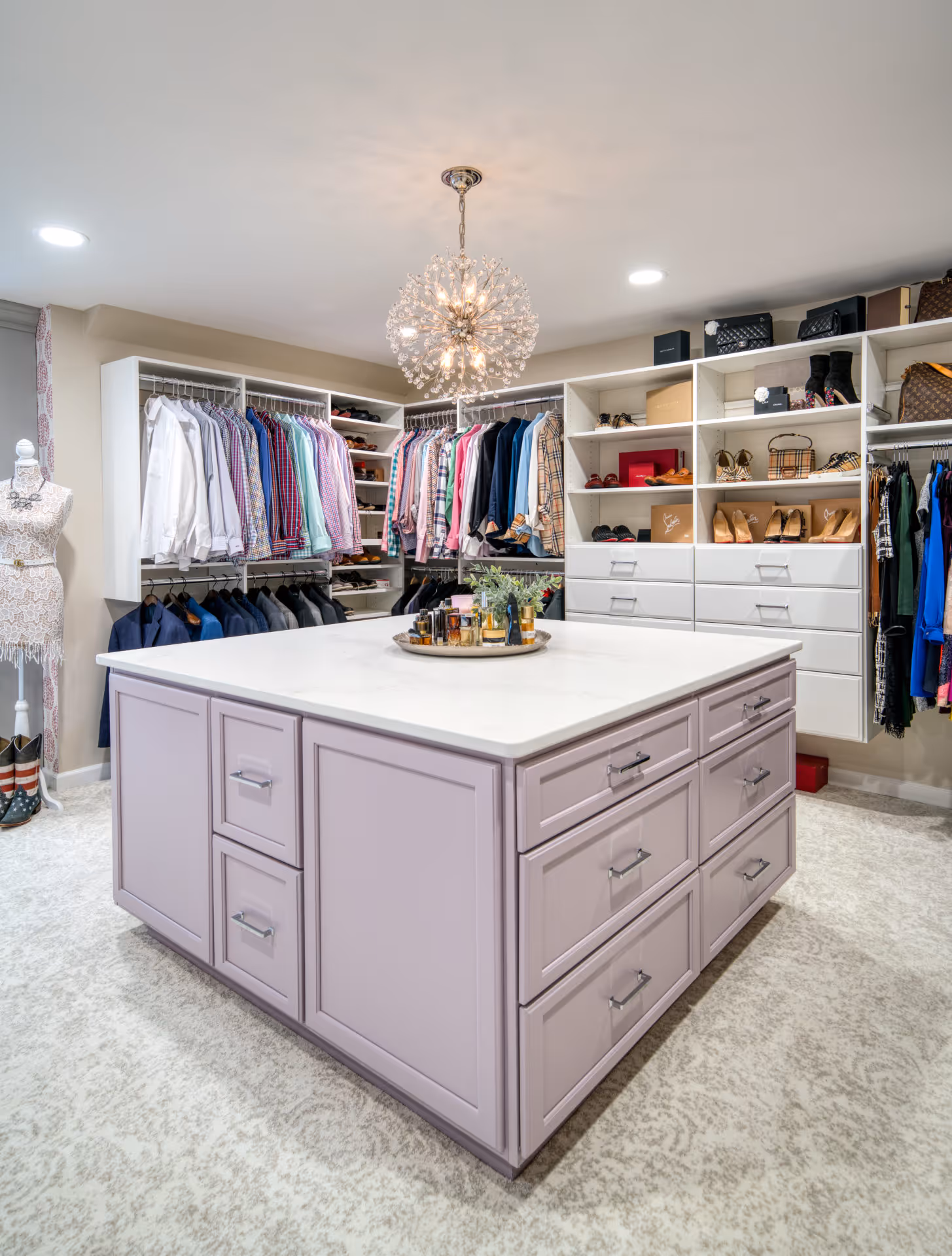 Luxury walk-in closet with organized shelves, purple island, and stylish chandelier in Elizabethtown, PA.