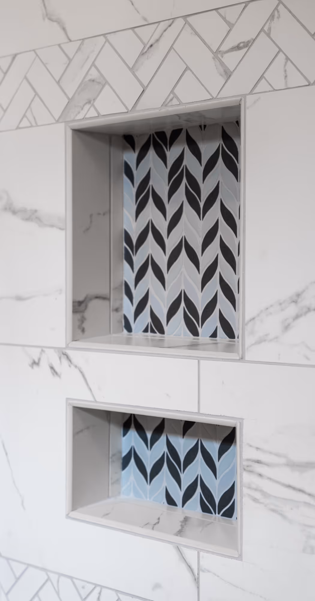 Stylish bathroom shower nook detail featuring blue and black patterned tiles, modern design elements in enola, pa.