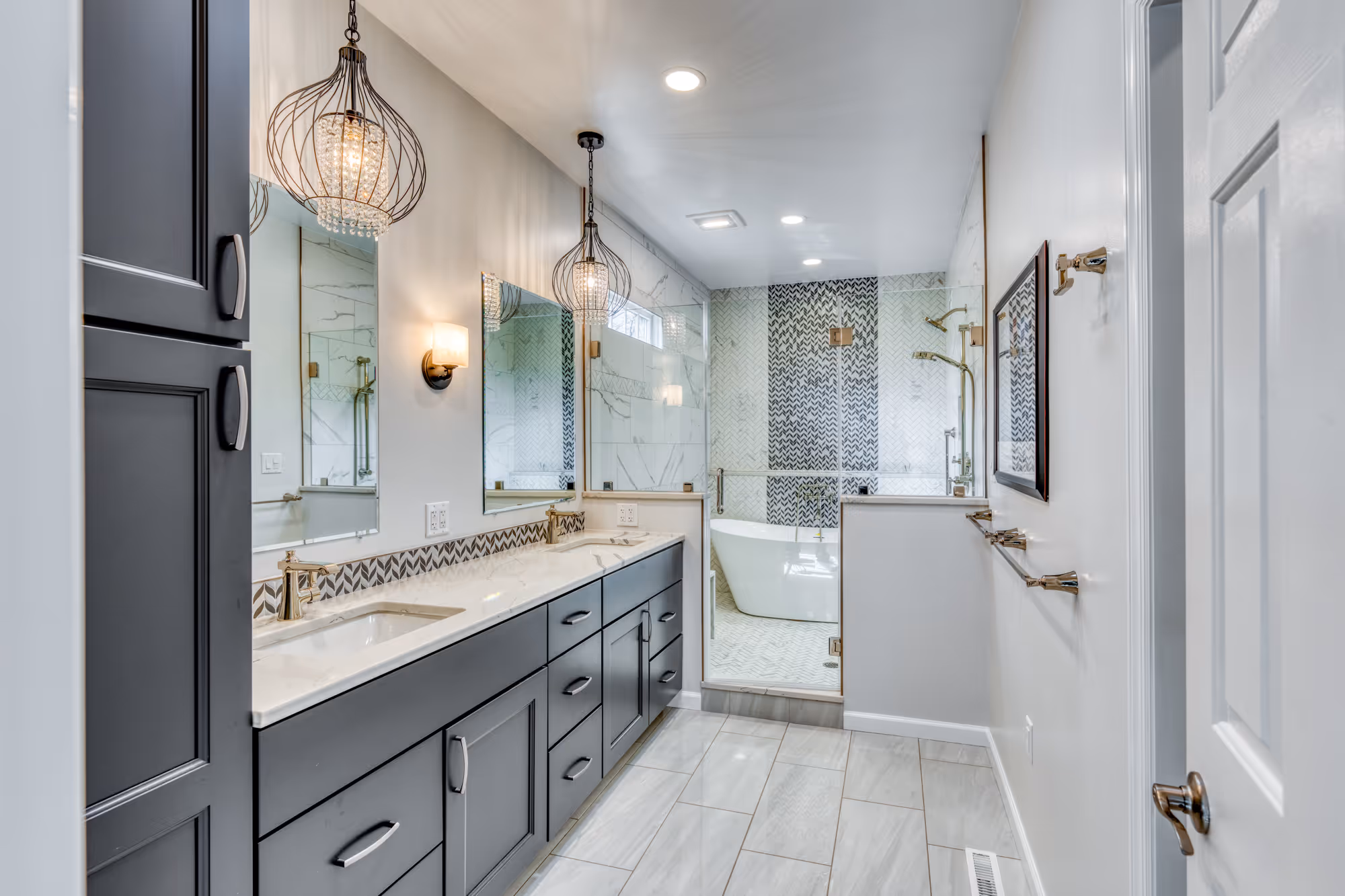 Modern bathroom remodel in Camp Hill, PA with gray cabinetry, gold fixtures, and elegant lighting.