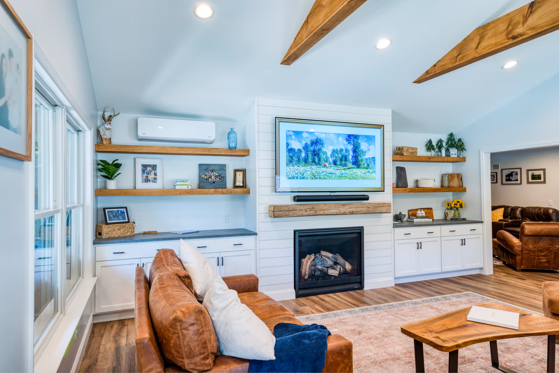 Modern living room in Dillsburg, PA featuring a cozy leather sofa, wood shelves, and a sleek fireplace.