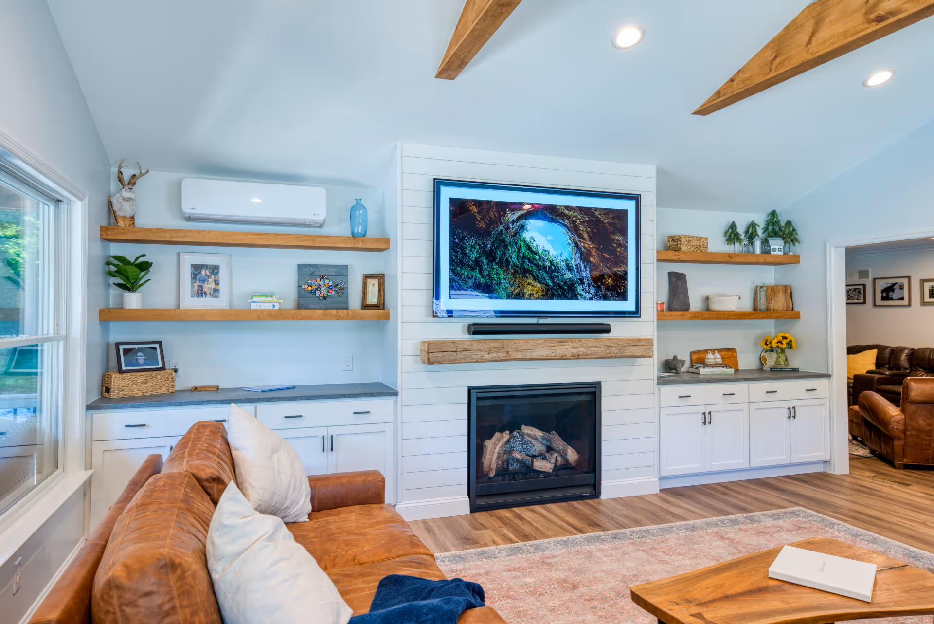 Modern living room featuring a leather sofa, wooden shelves, and a TV above a fireplace in Dillsburg, PA.
