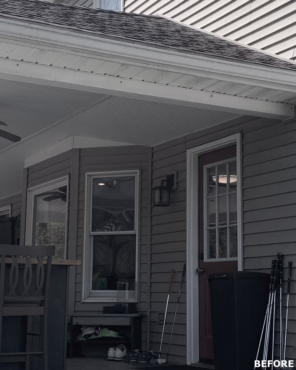 Before photo of a Dillsburg, PA exterior porch featuring gray siding, a door with window panels, and outdoor seating.