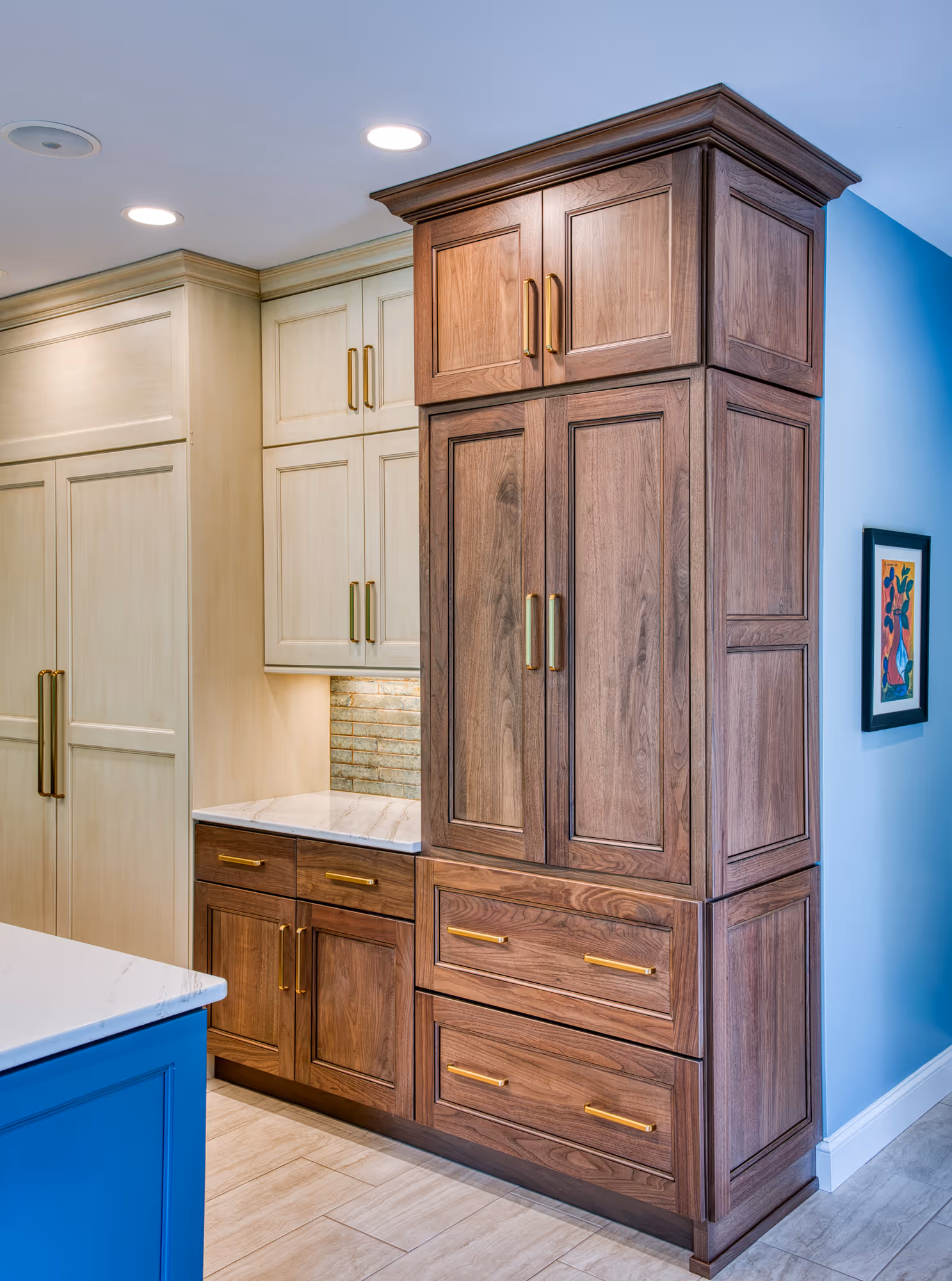 Modern kitchen cabinetry in Mechanicsburg, PA, featuring walnut wood, white cabinets, gold handles, and elegant countertop.