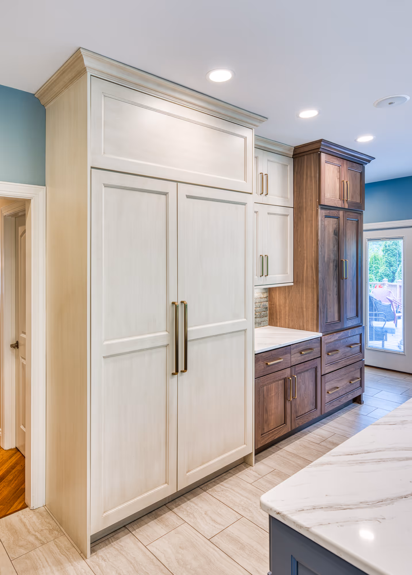 Modern kitchen in Mechanicsburg, PA, featuring dual-tone cabinetry in white and brown, marble countertop, and stylish lighting.