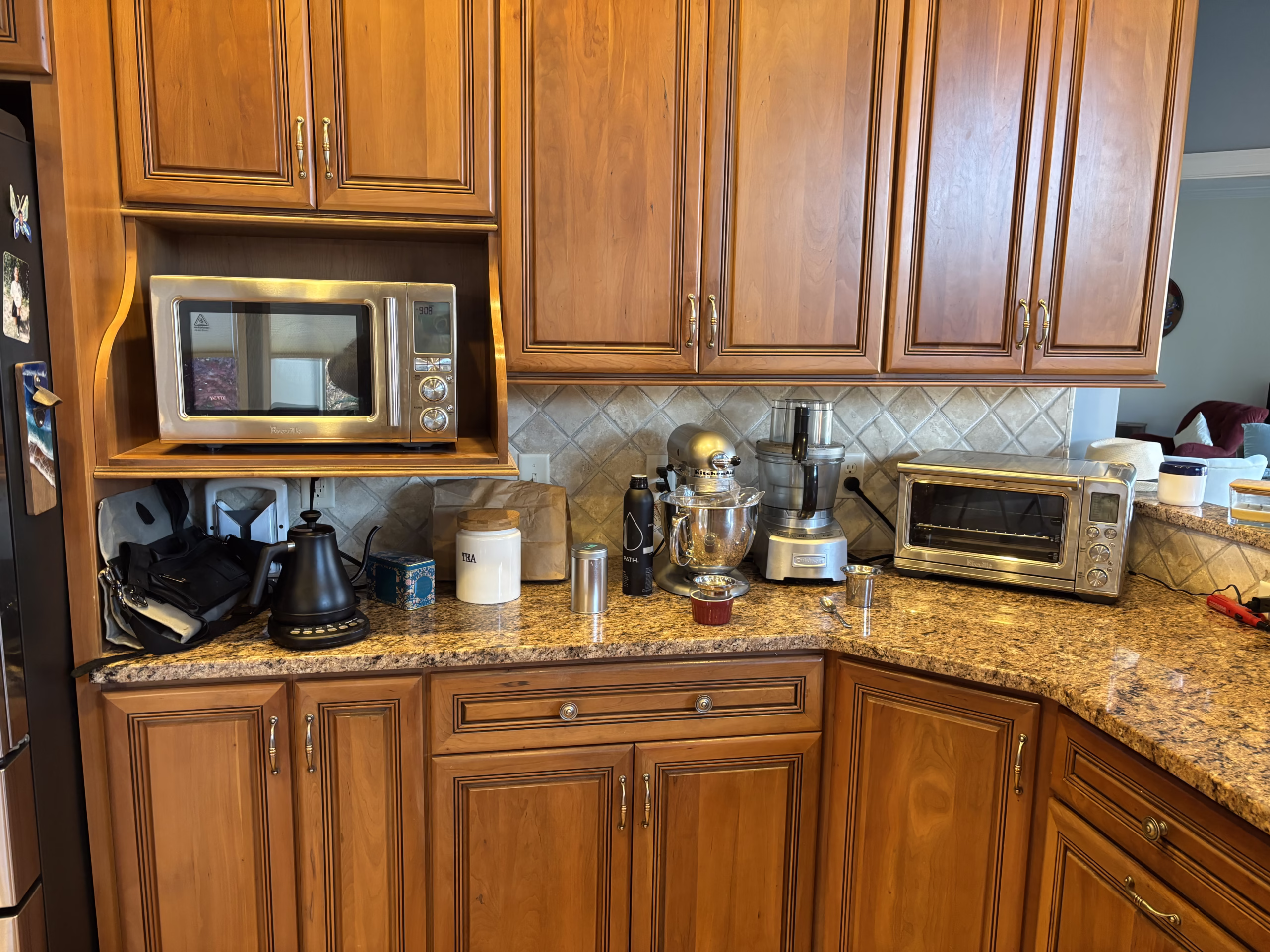 Traditional kitchen with wood cabinets and granite countertops in Mechanicsburg, PA featuring various appliances and kitchenware.