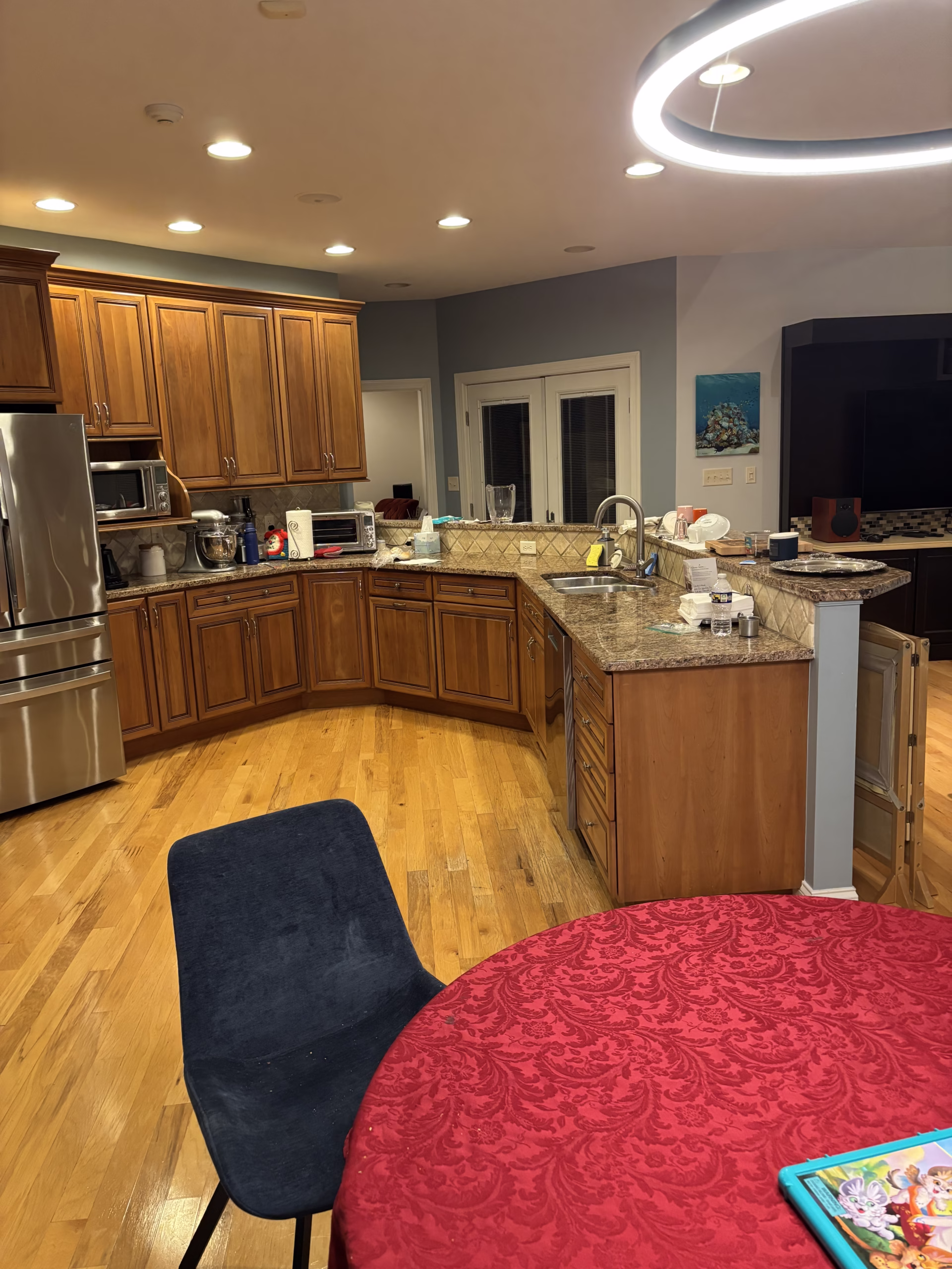 Spacious kitchen in Mechanicsburg, PA with brown wood cabinets, granite countertops, and modern lighting.
