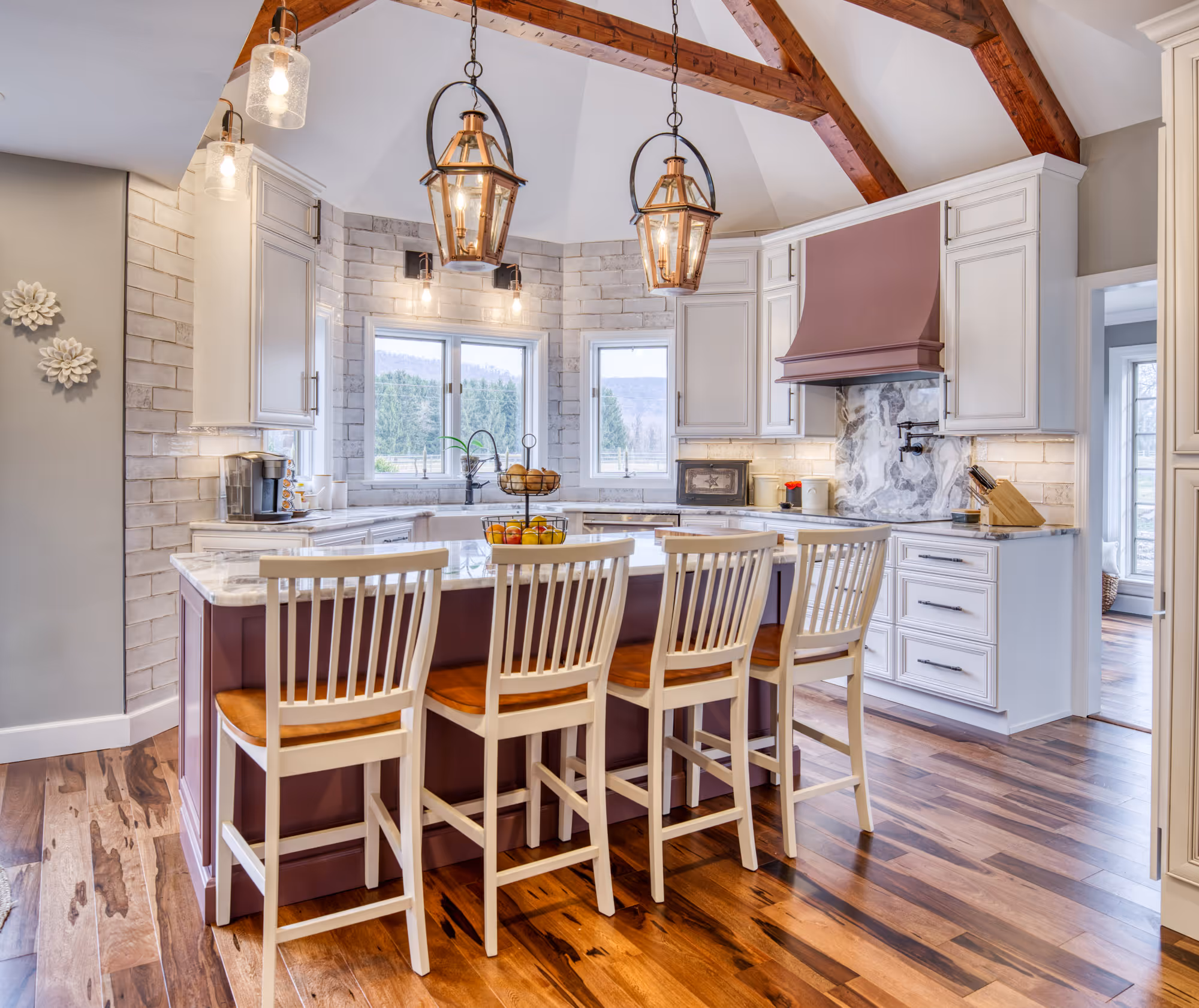 Beautiful modern kitchen in enola, pa featuring white cabinets, wooden beams, and elegant pendant lighting