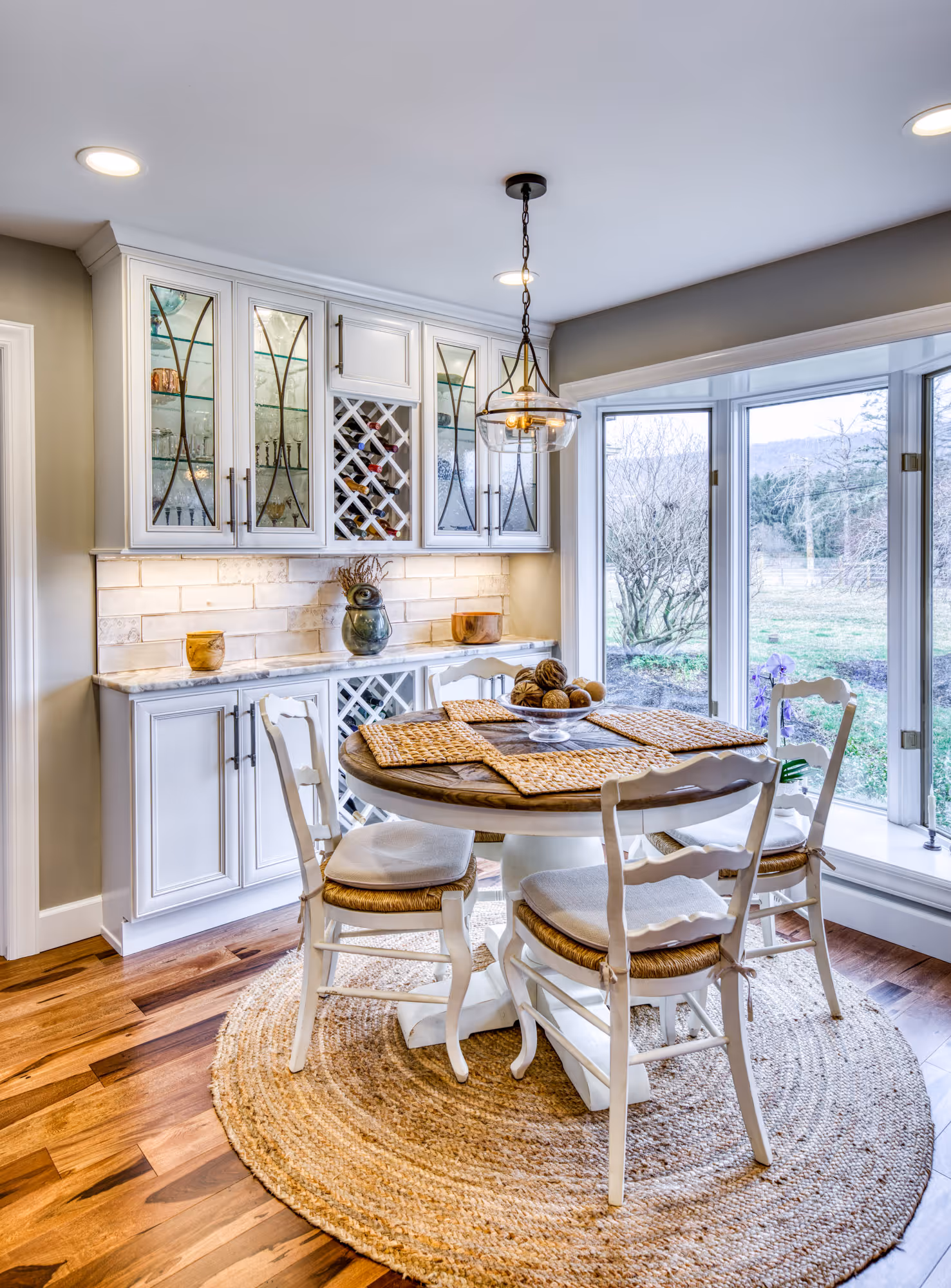 Modern kitchen dining area in enola, pa featuring a round table, white cabinets, and natural decor elements