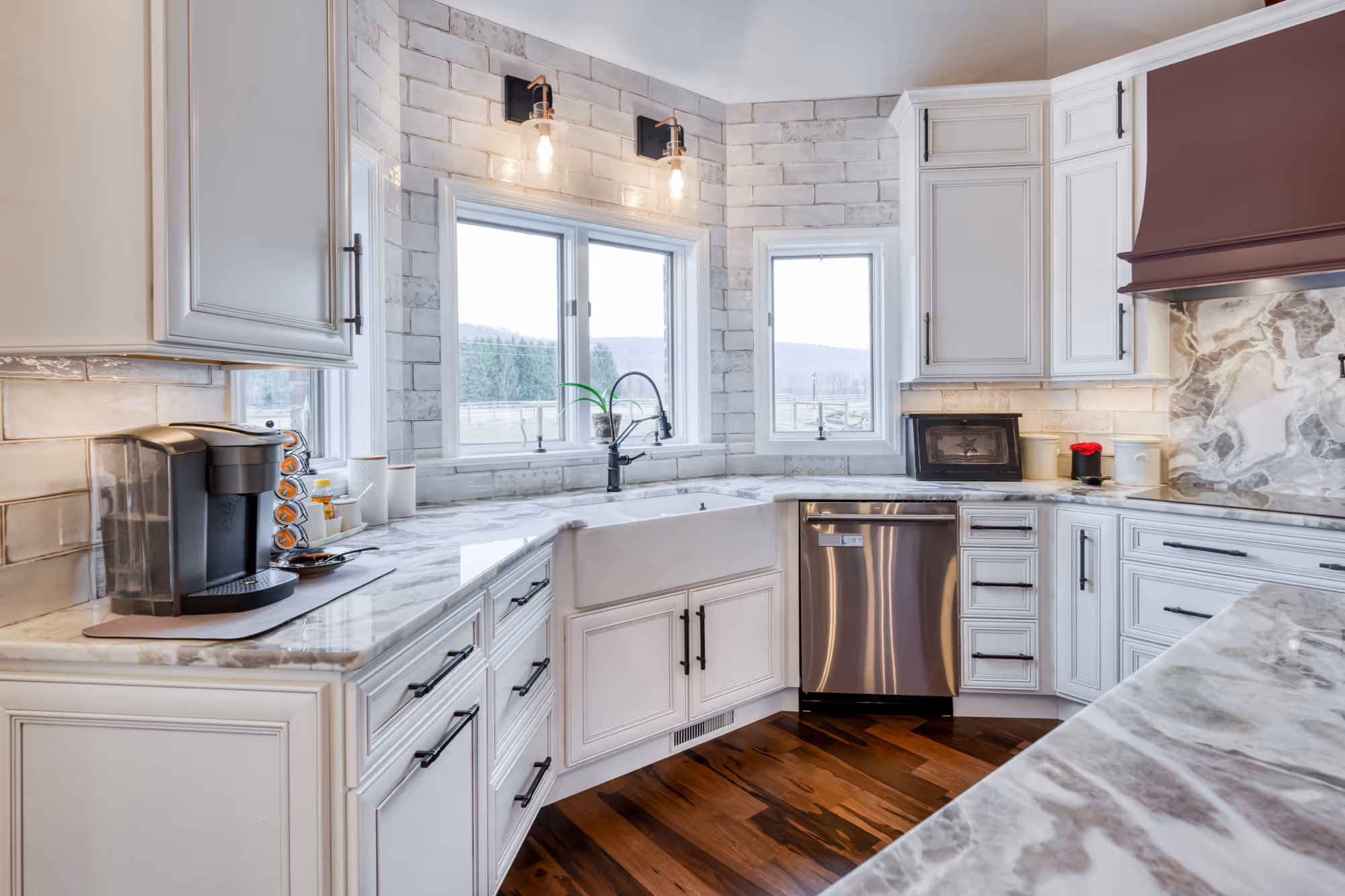 Modern kitchen remodel in enola, pa featuring white cabinetry, marble countertops, and cozy lighting.