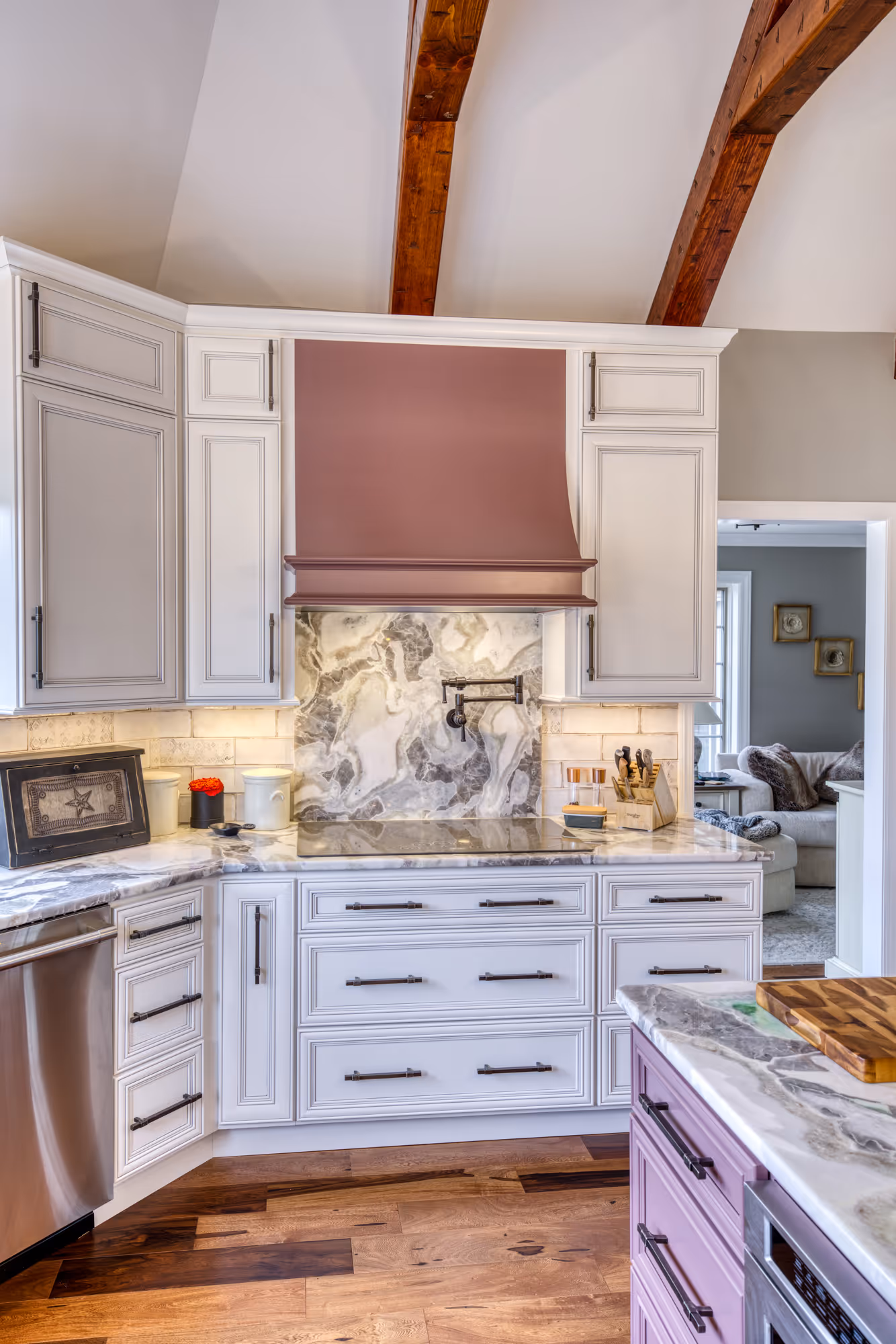 Elegant kitchen featuring a purple hood, marble countertops, and rustic wooden beams in enola, pa.