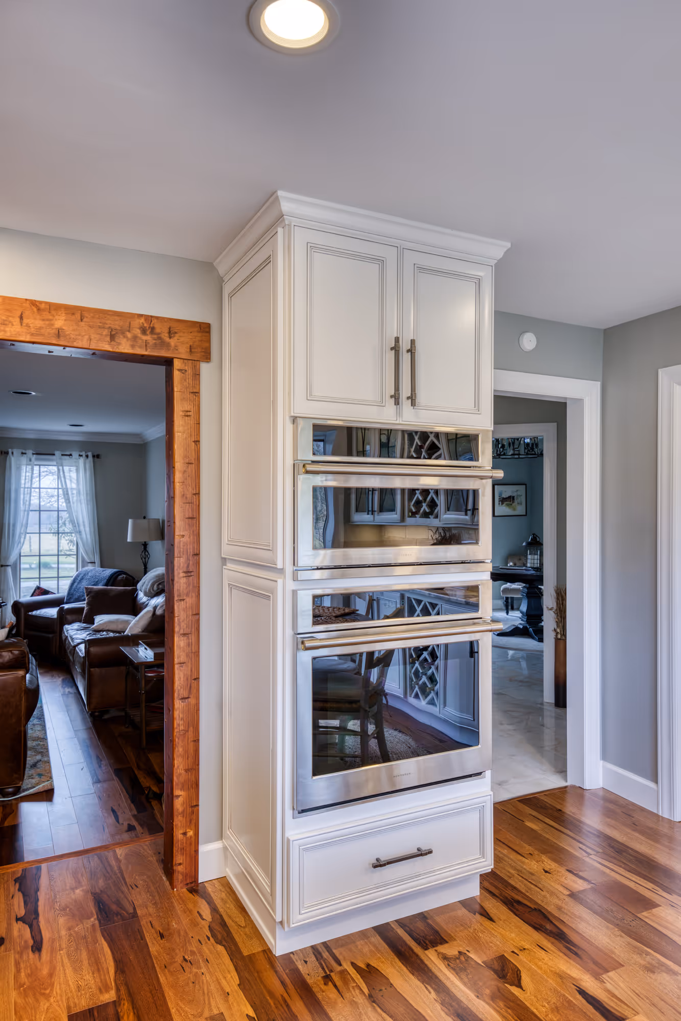 Modern kitchen in Enola, PA featuring sleek double oven, wood accents, and warm hardwood flooring.