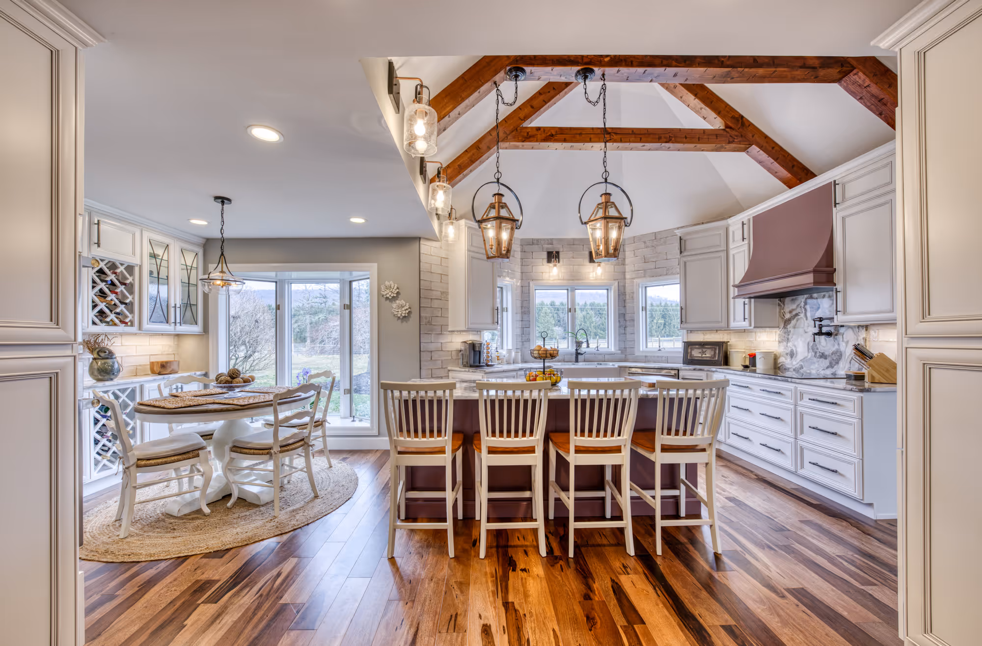 Modern kitchen remodel featuring white cabinets, wooden beams, and a cozy dining area in Enola, PA