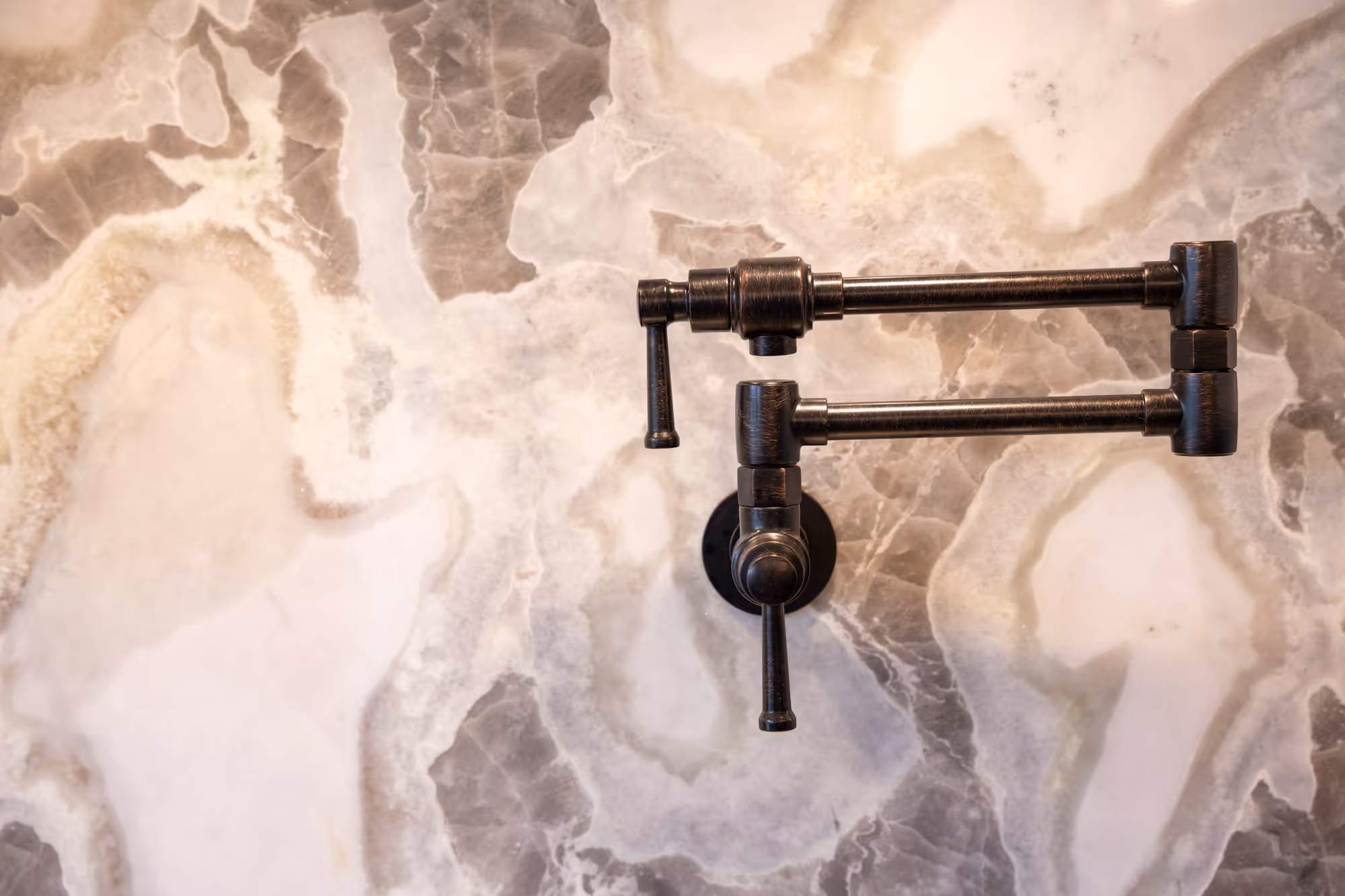 Industrial-style pot filler faucet mounted on a stunning marble backsplash in a kitchen in enola, pa