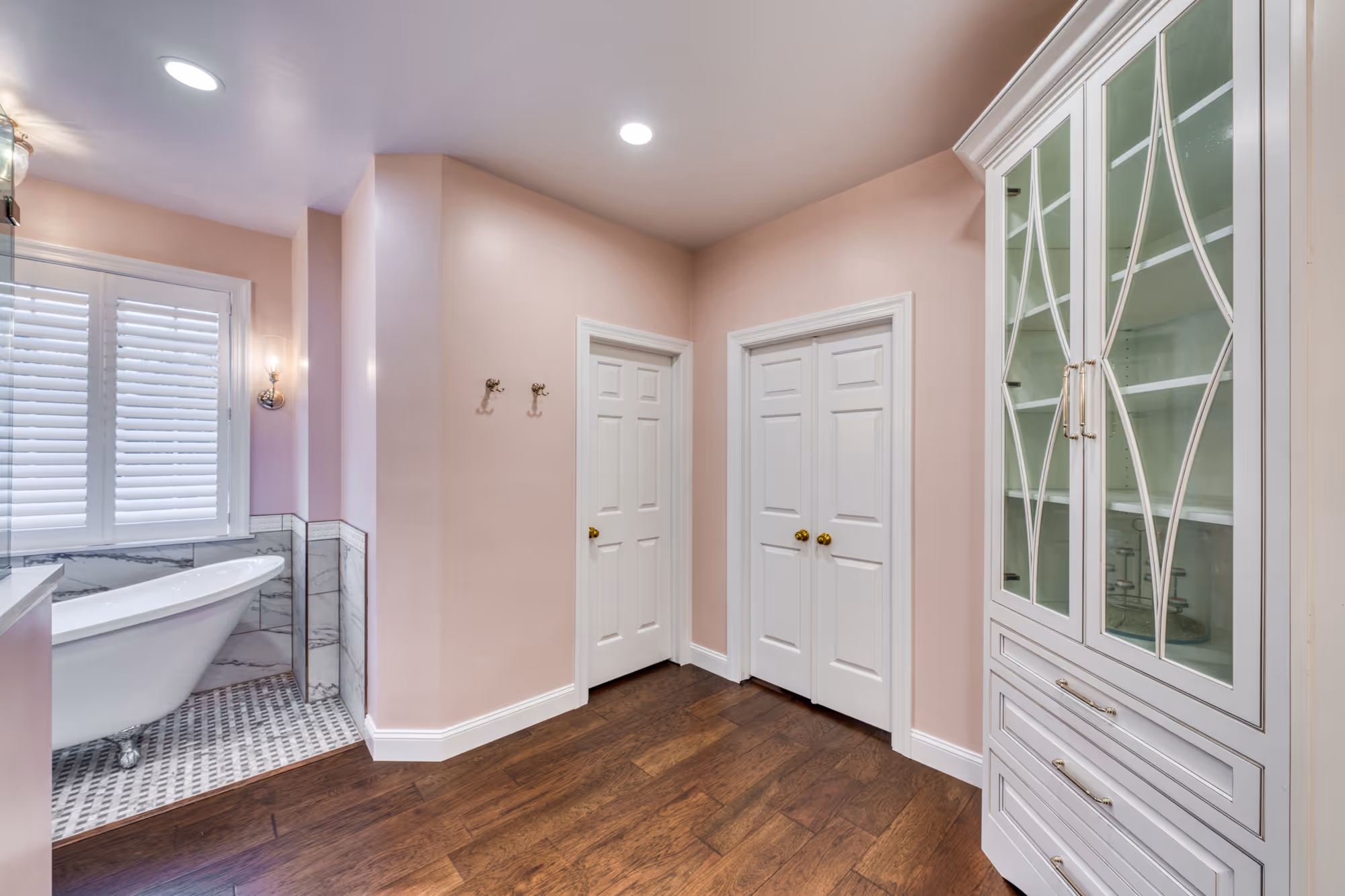 Elegant bathroom in mechanicsburg, pa featuring pink walls, marble details, and a freestanding tub.