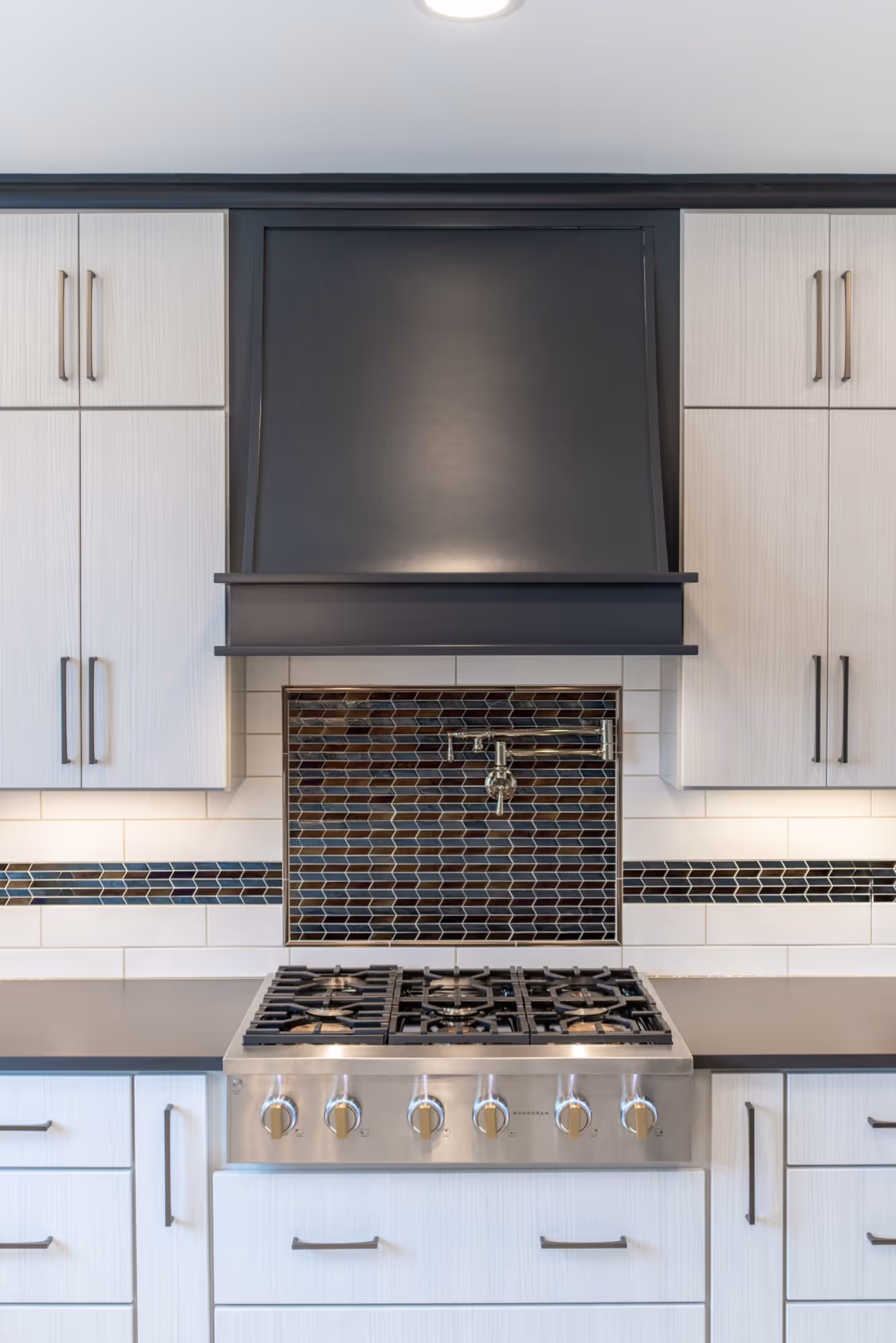 Modern kitchen design in Lewisberry, PA features a sleek gas stove, stylish backsplash, and contemporary cabinetry.