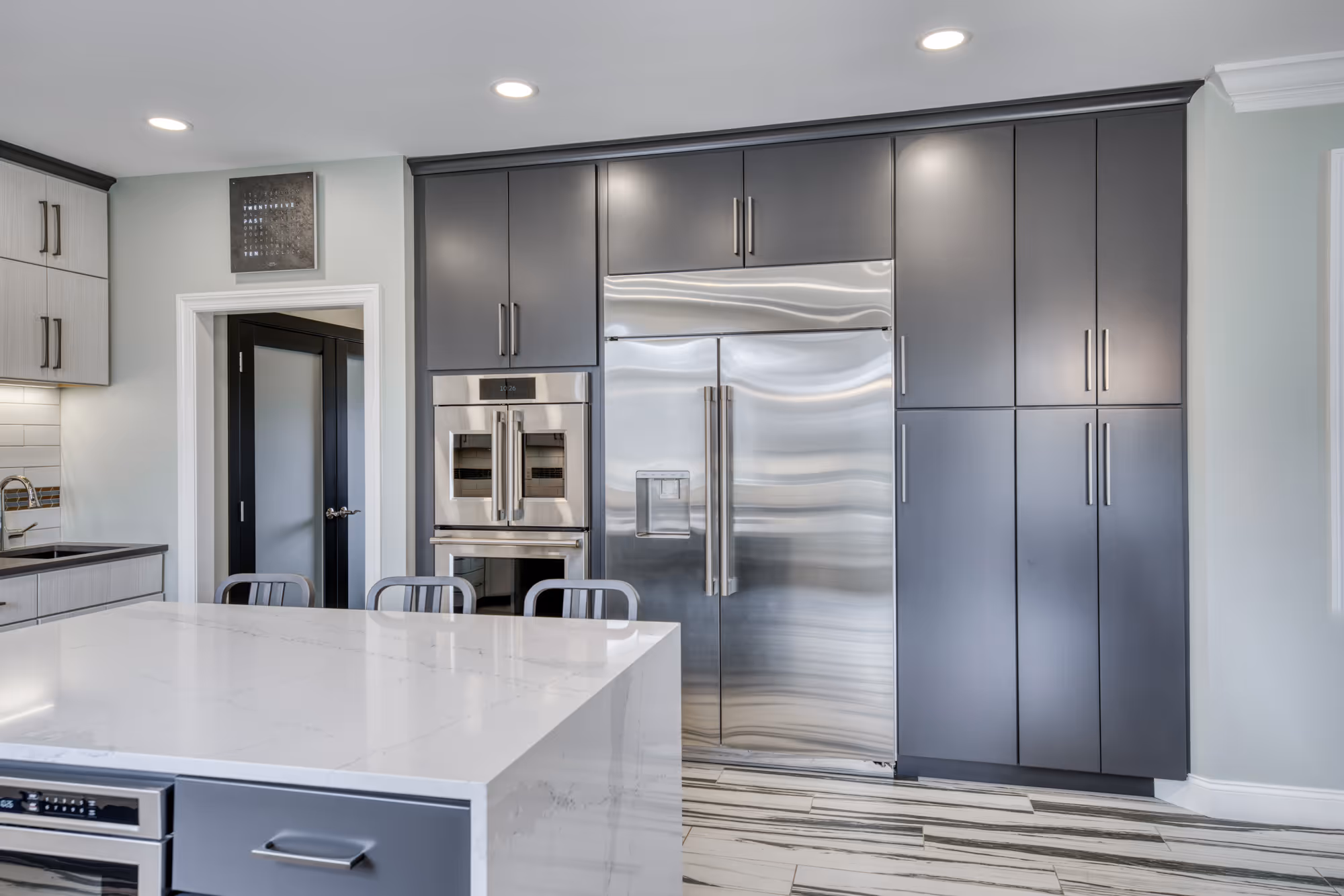 Modern kitchen in Lewisberry, PA featuring gray cabinets, marble countertops, and stainless steel appliances.