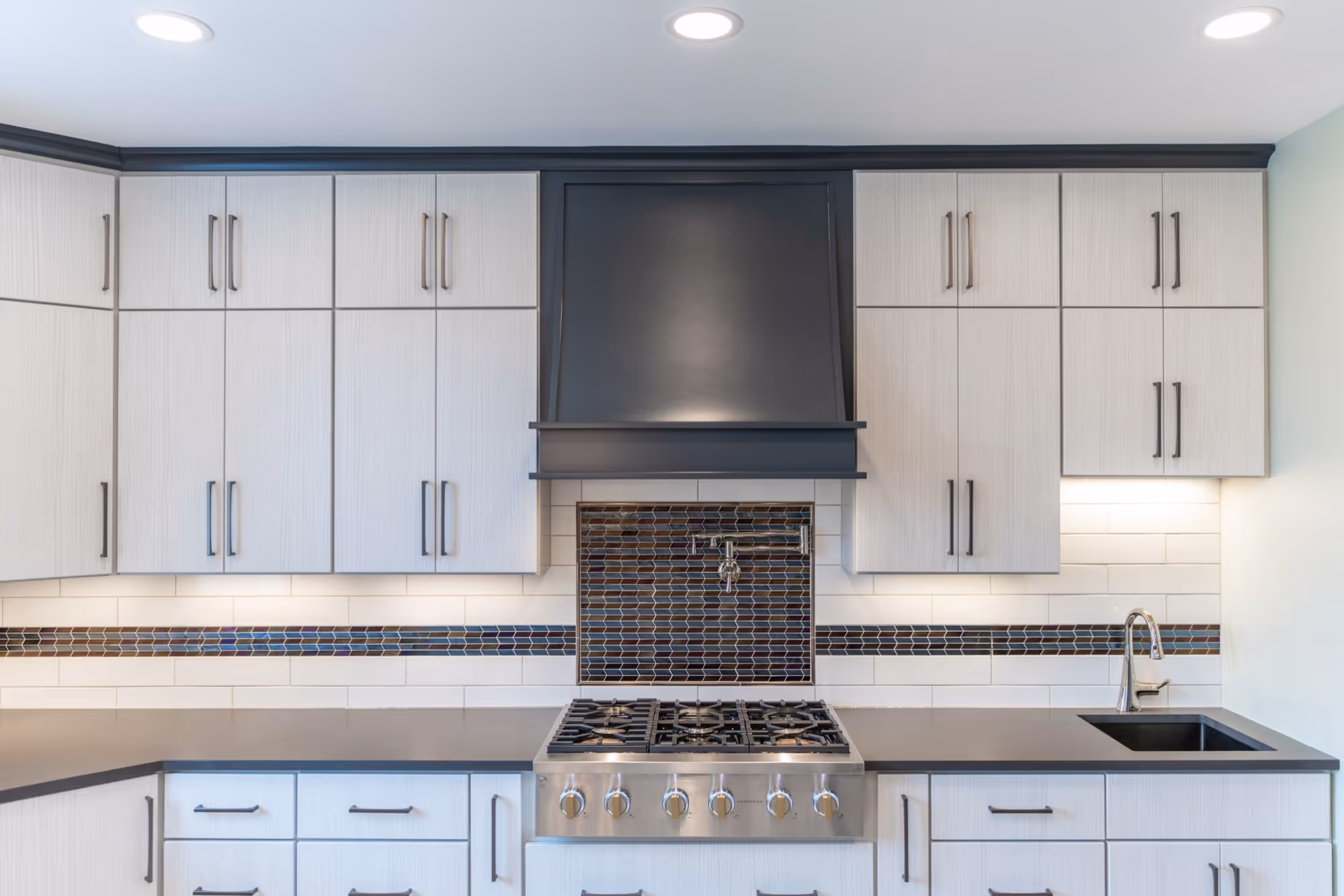 Modern kitchen with shaker cabinets, sleek black countertop, and decorative tile backsplash in Lewisberry, PA