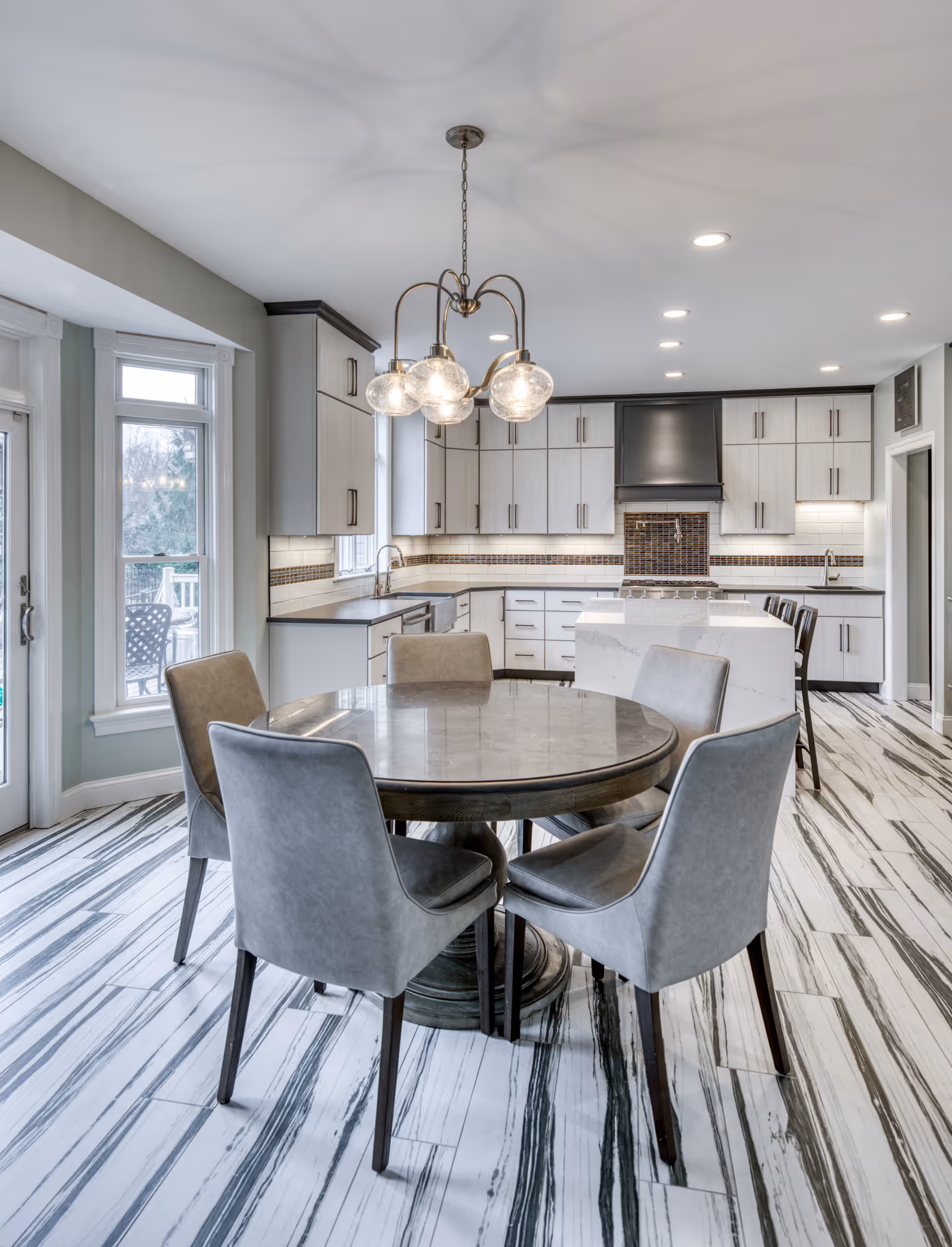 Modern kitchen dining area featuring a round table, stylish chairs, and unique patterned flooring in lewisberry, pa.