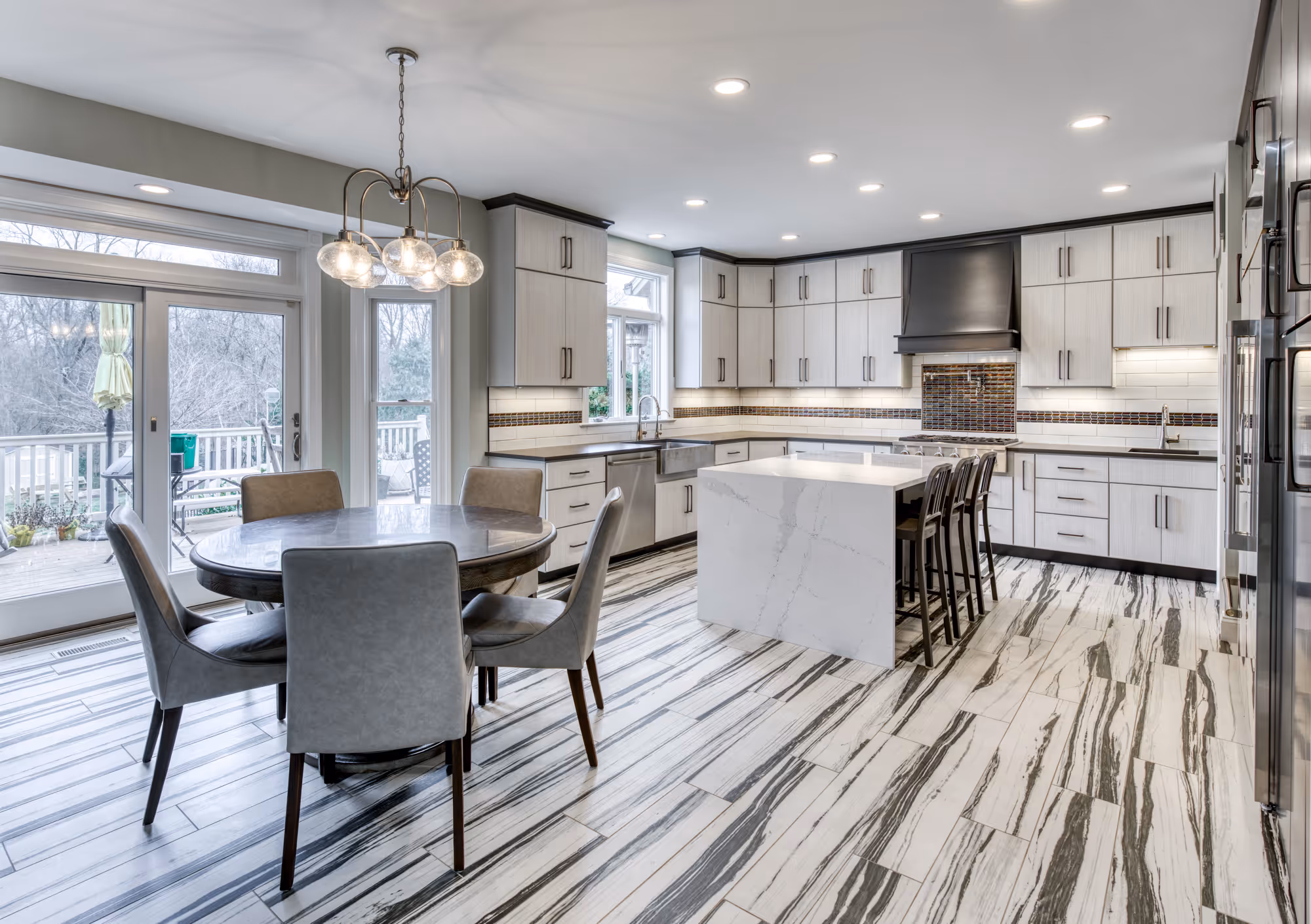 Modern kitchen in Lewisberry, PA featuring gray and white cabinetry, marble island, and contemporary lighting.