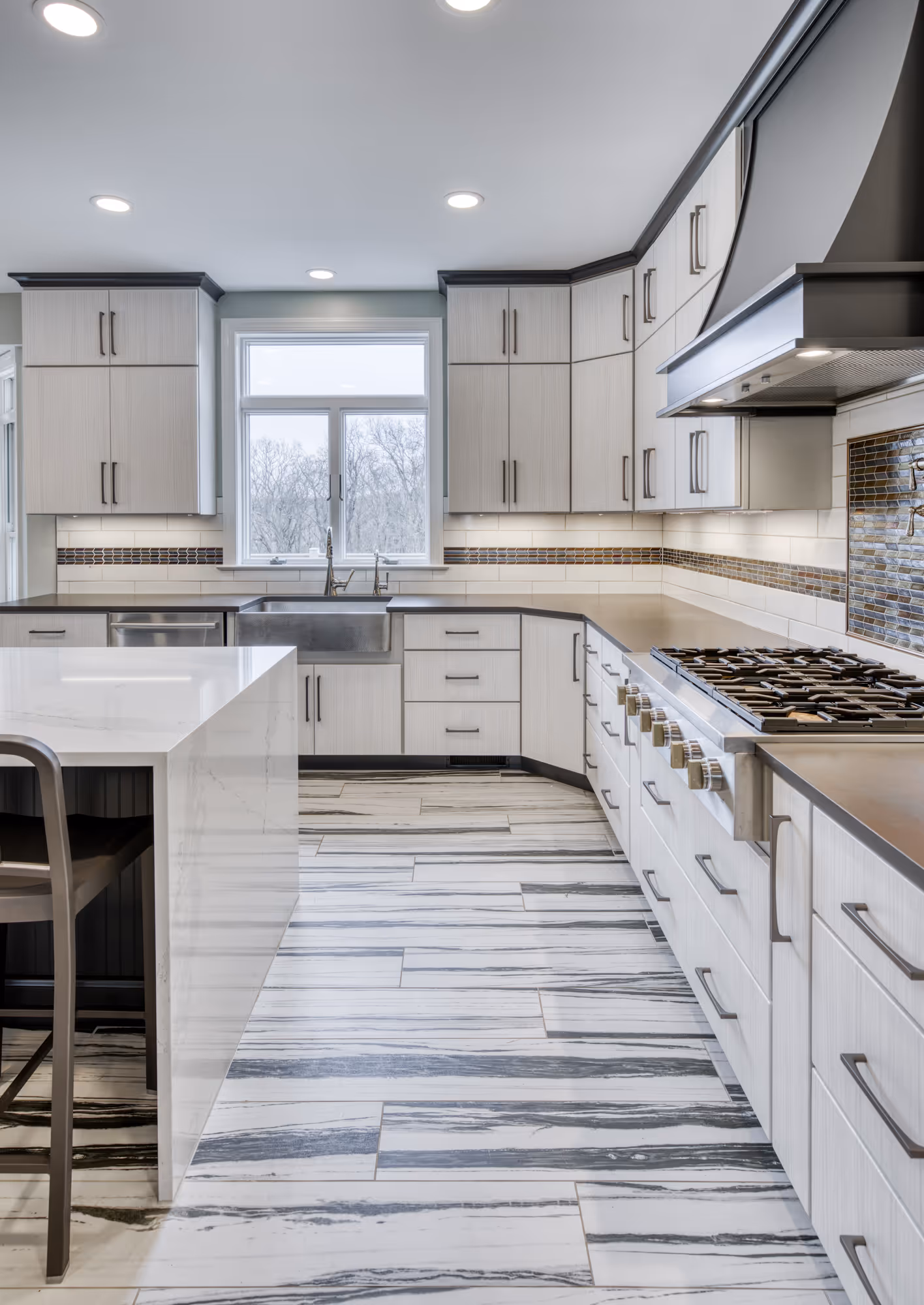 Modern kitchen with white and gray tile flooring, sleek cabinetry, and stainless steel appliances in Lewisberry, PA.