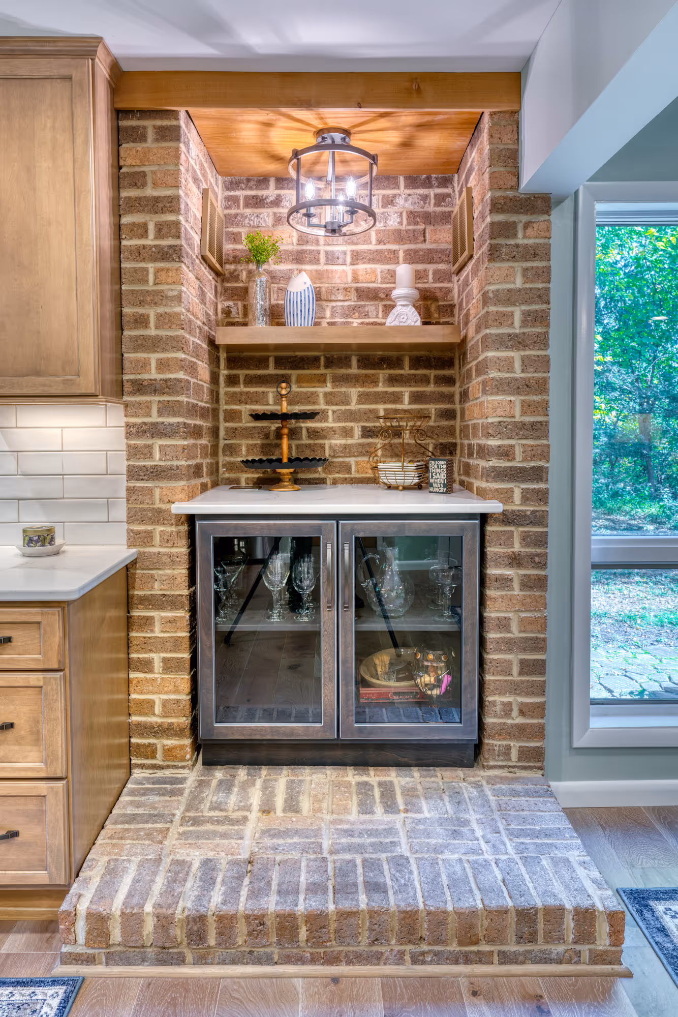 Stylish kitchen feature in Harrisburg, PA, showcasing a brick wall with glass cabinetry and wooden accents.