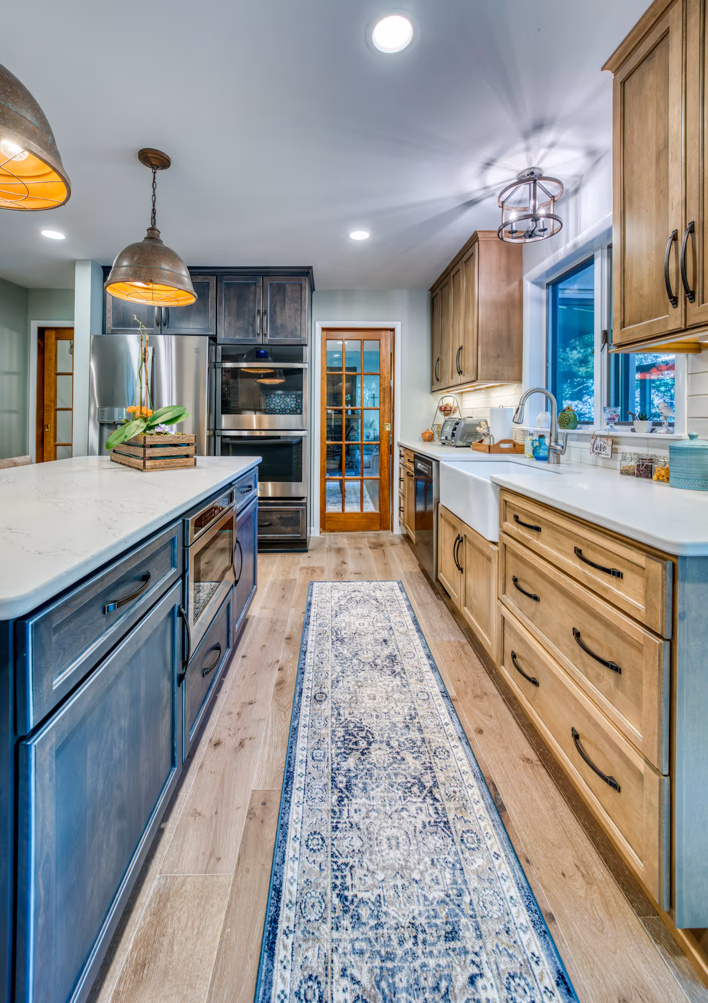 Modern kitchen featuring dark and light wood cabinets, a patterned runner, and stainless steel appliances in harrisburg, pa.