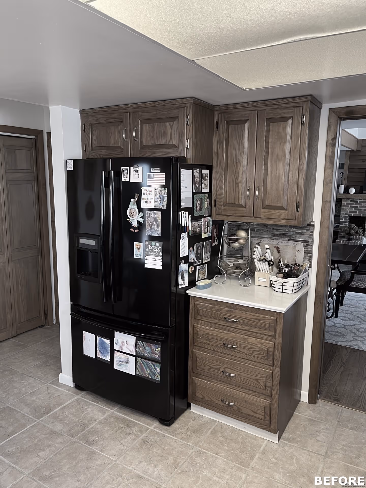 Modern kitchen featuring black refrigerator and wooden cabinets in Harrisburg, PA, showcasing family photos and stylish decor.