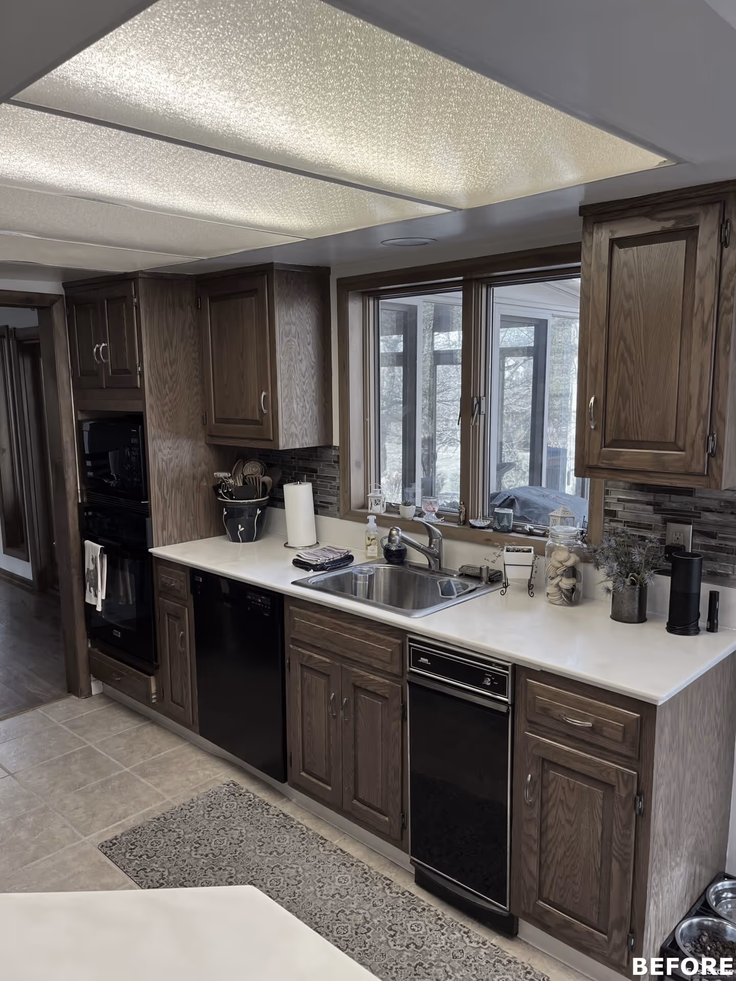 Modern kitchen with dark wood cabinets and a dual sink, featuring natural light and a tile backsplash in harrisburg, pa