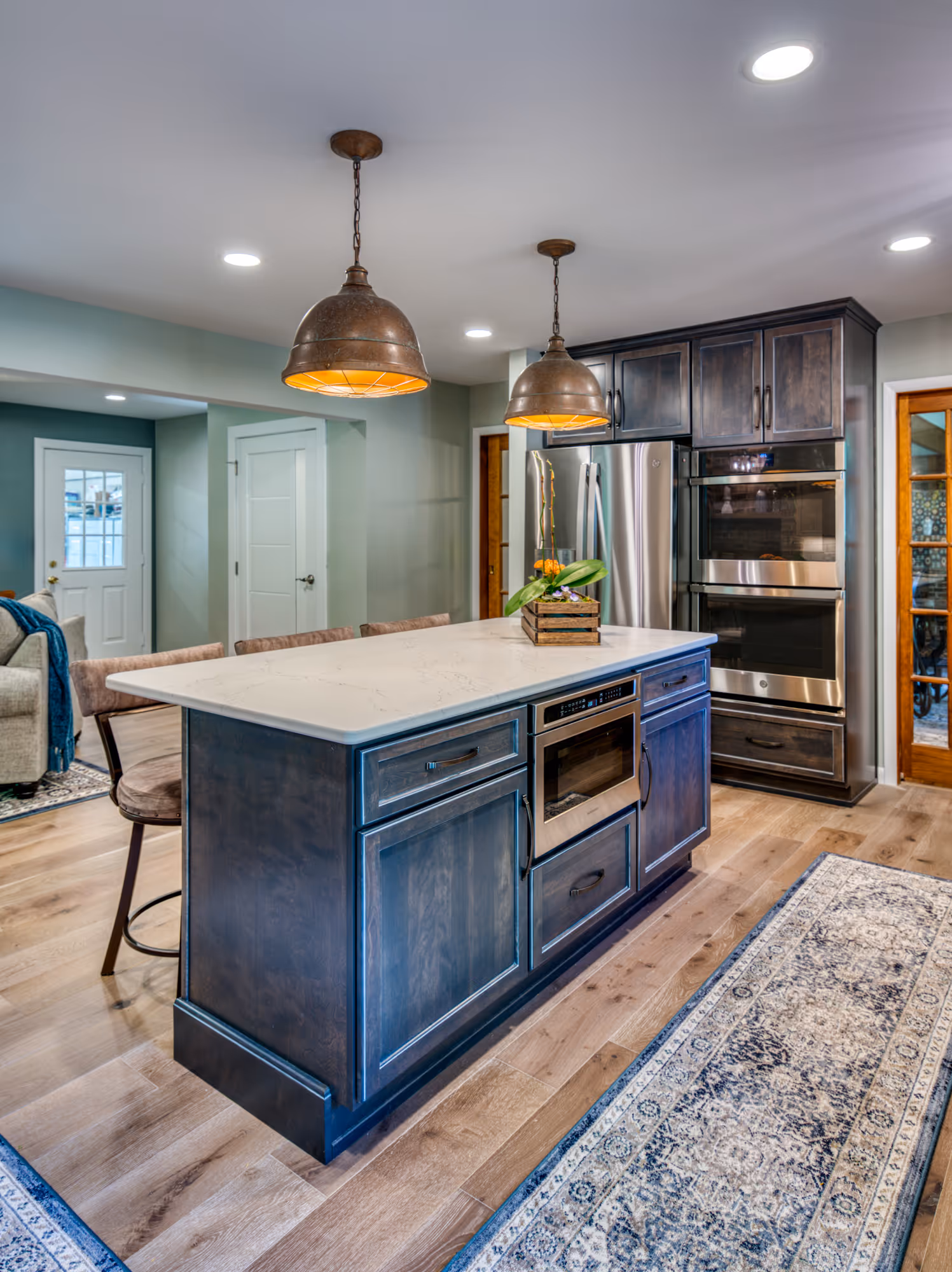 Modern kitchen with dark wood cabinets, marble countertop, and industrial pendant lights in Harrisburg, PA.