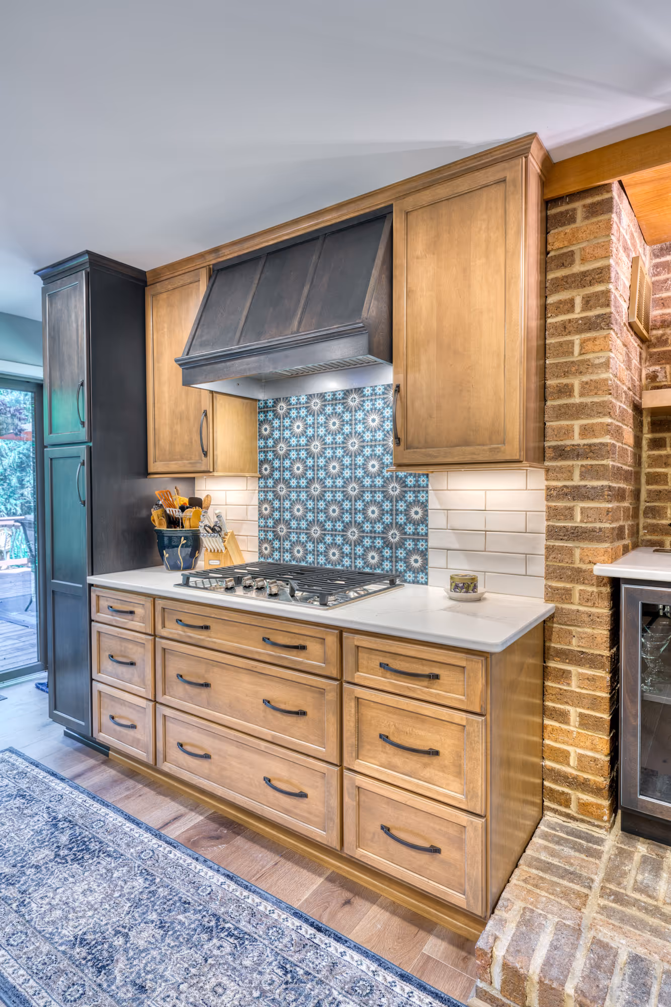 Modern kitchen in Harrisburg, PA featuring wood cabinets, intricate tile backsplash, and a stylish range hood.