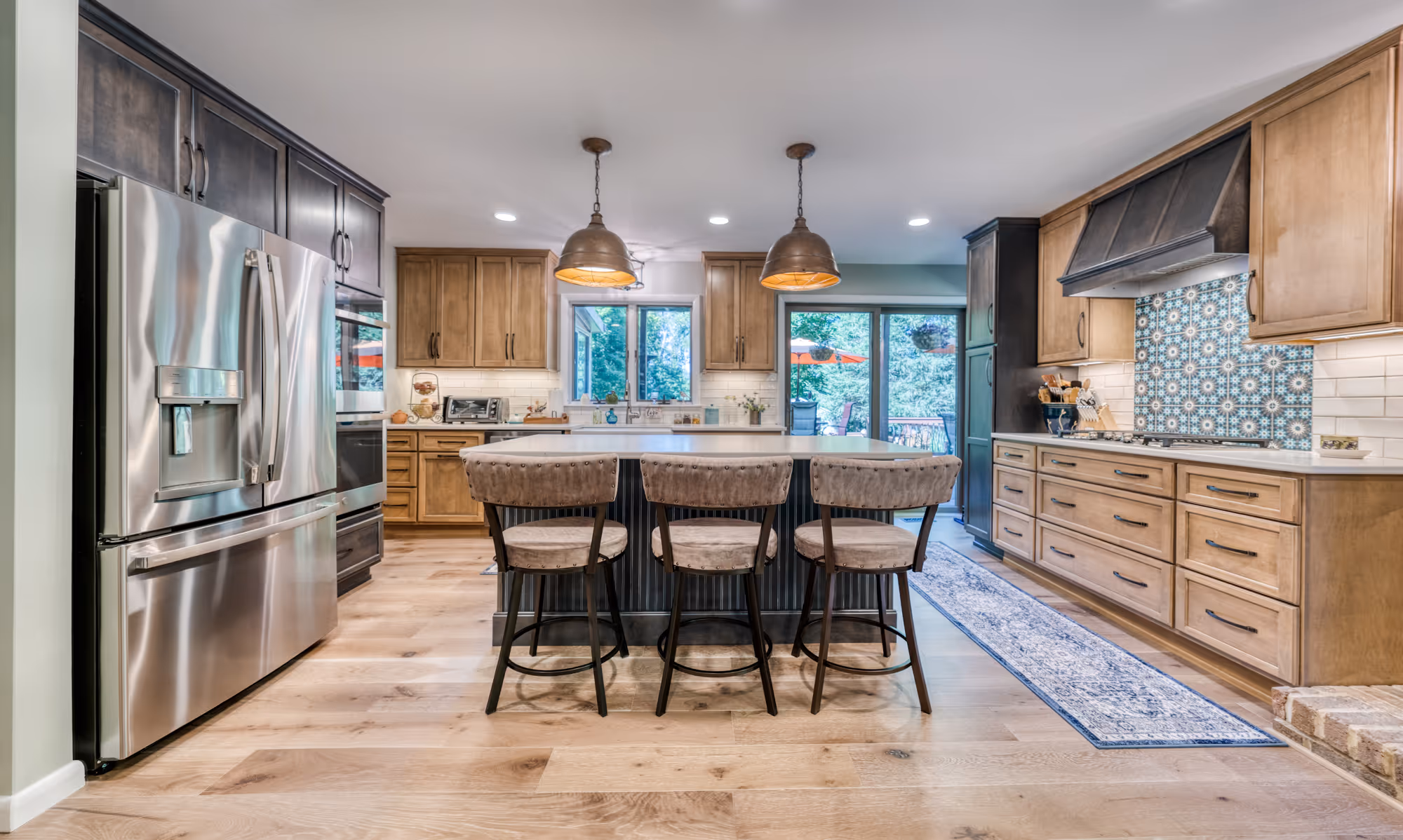 Transitional kitchen in Harrisburg, PA with multi-tone cabinetry, a large island, and stylish lighting