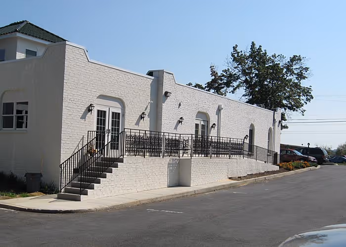 Modern exterior view of a white brick building with stairs and wrought iron railings in Camp Hill, PA.