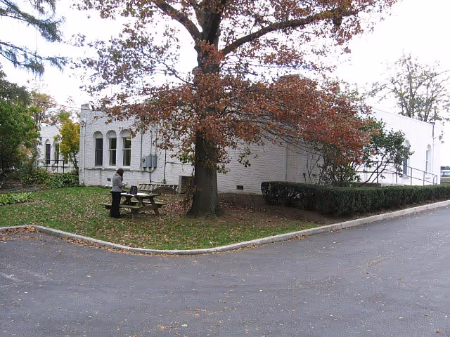 Exterior view of a brick building surrounded by landscaped greenery in Camp Hill, PA