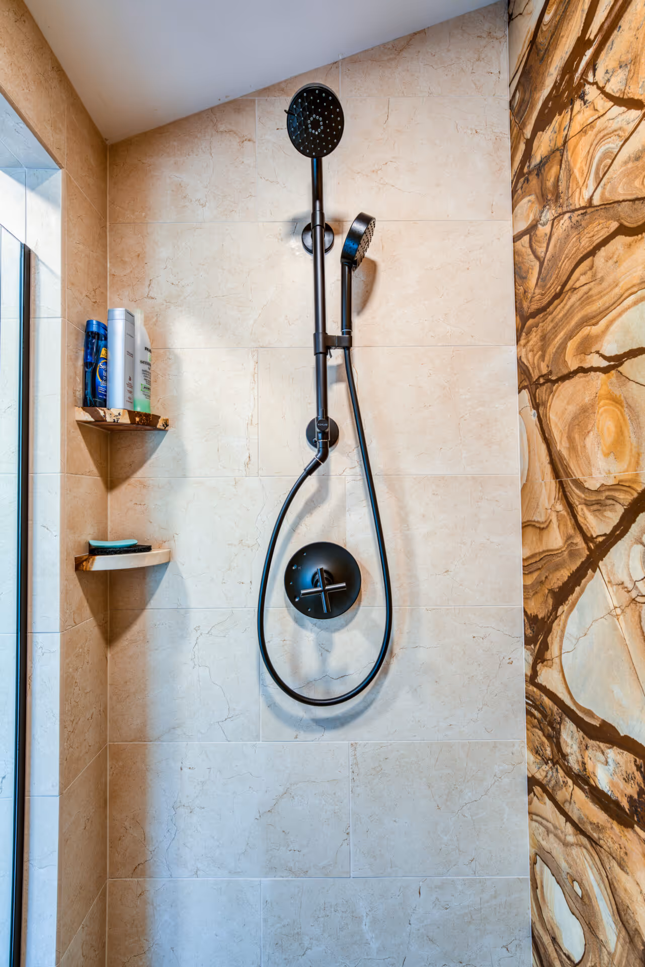 Modern bathroom shower featuring a black handheld and rainfall showerhead with a textured tile wall in Dillsburg, PA.