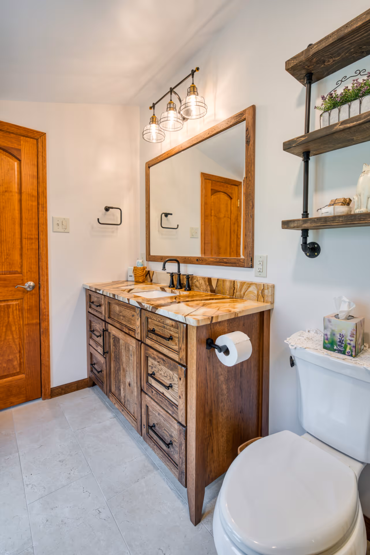 Rustic bathroom with wooden vanity, natural stone countertop, and elegant lighting in Dillsburg, PA