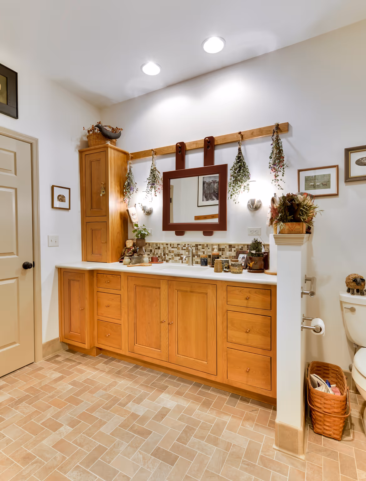 Transitional bathroom in Carlisle, PA showcasing wood cabinetry, decorative mirror, and tiled floor.