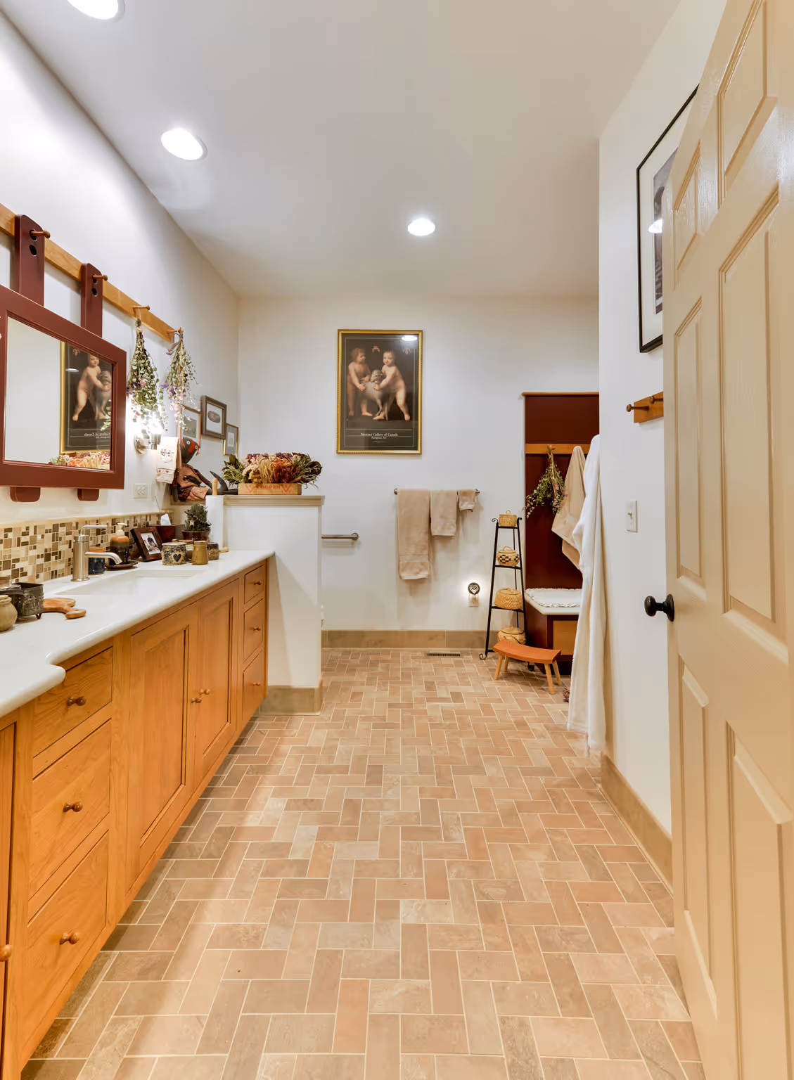 Spacious rustic bathroom featuring wood cabinetry and artistic decor in Carlisle, PA