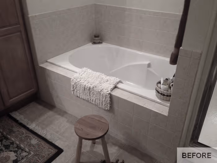 Transitional bathroom featuring a corner soaking tub, warm wood accents, and neutral tile in Carlisle, PA.