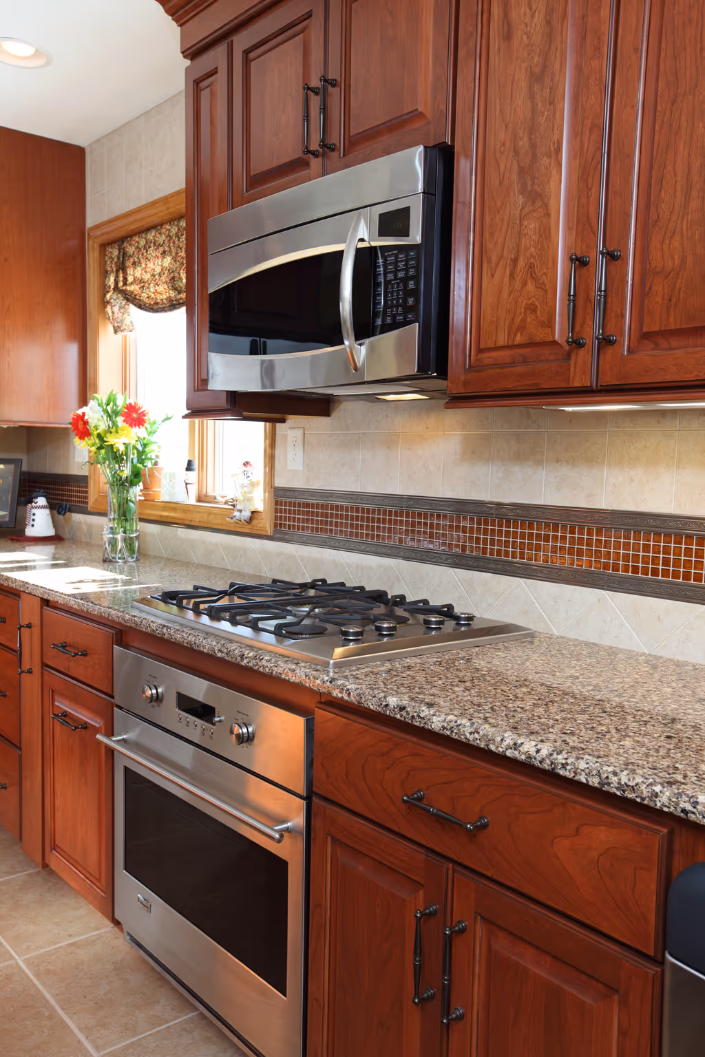 Modern kitchen in York, PA featuring granite countertop, stainless steel appliances, and rich wood cabinetry.