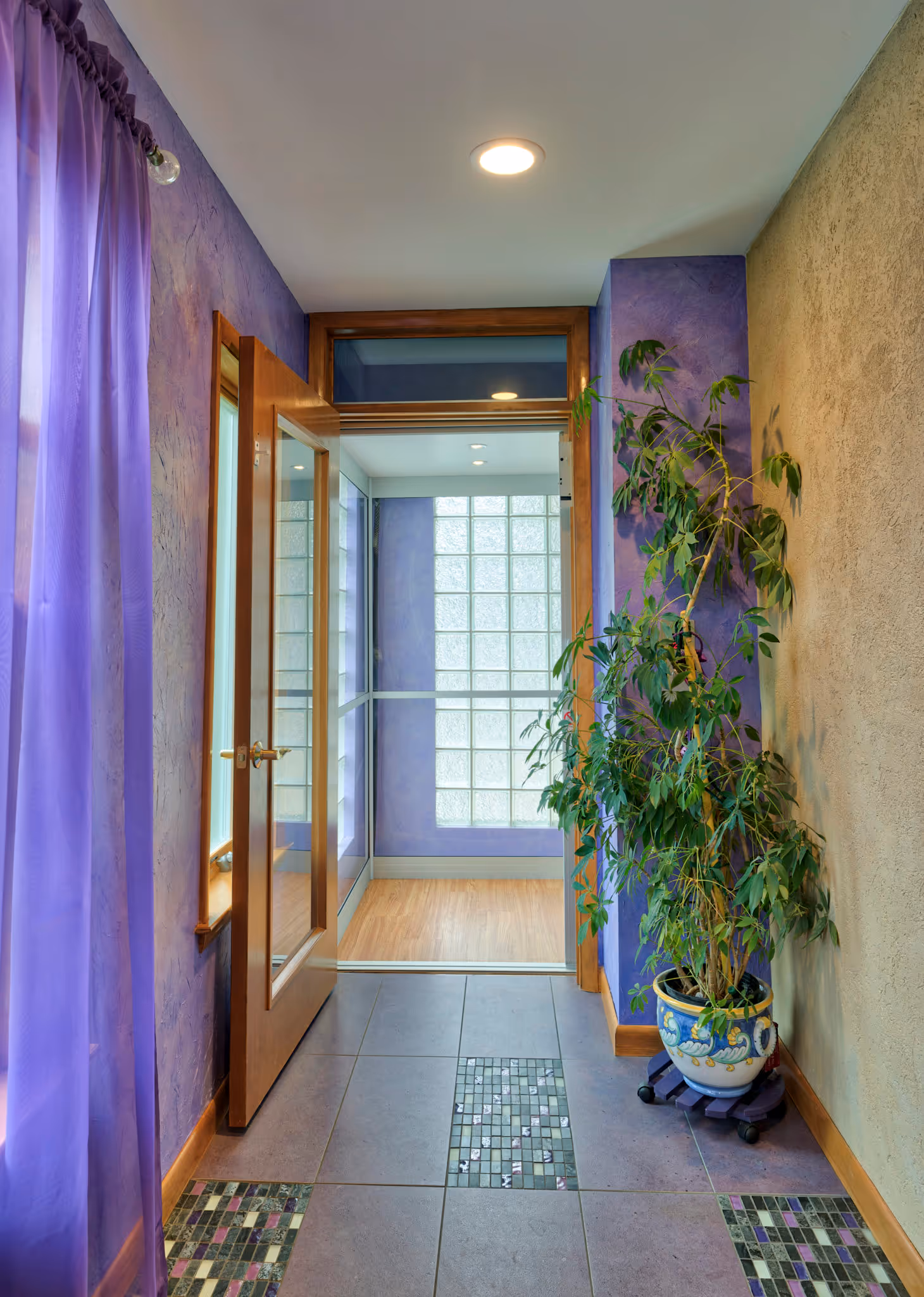 Welcoming hallway with purple walls, decorative tile flooring, and a potted plant in Camp Hill, PA